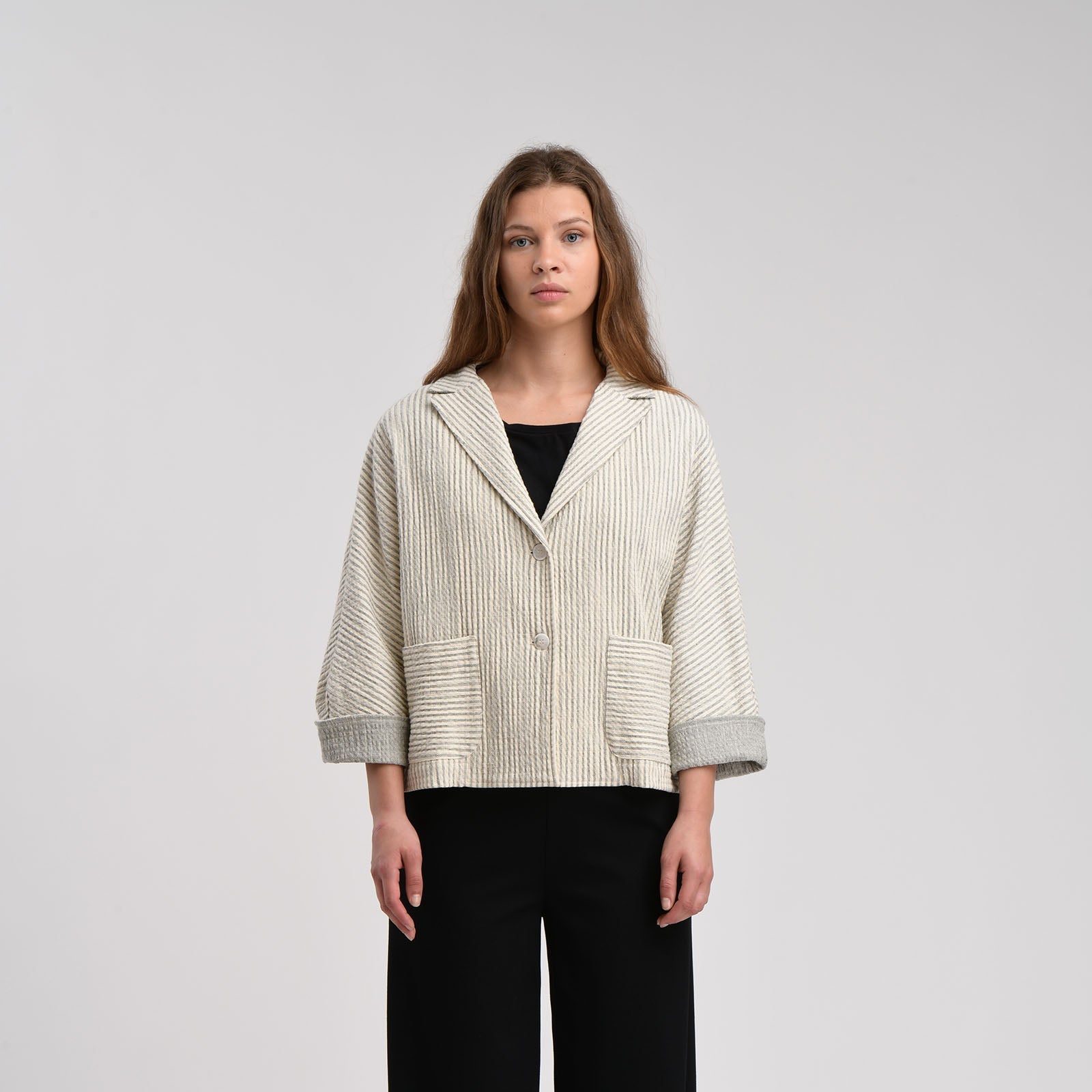 Off-white cropped blazer with thin gray stripes, notched collar, two patch pockets, and gray cuffs.  Single button closure.
