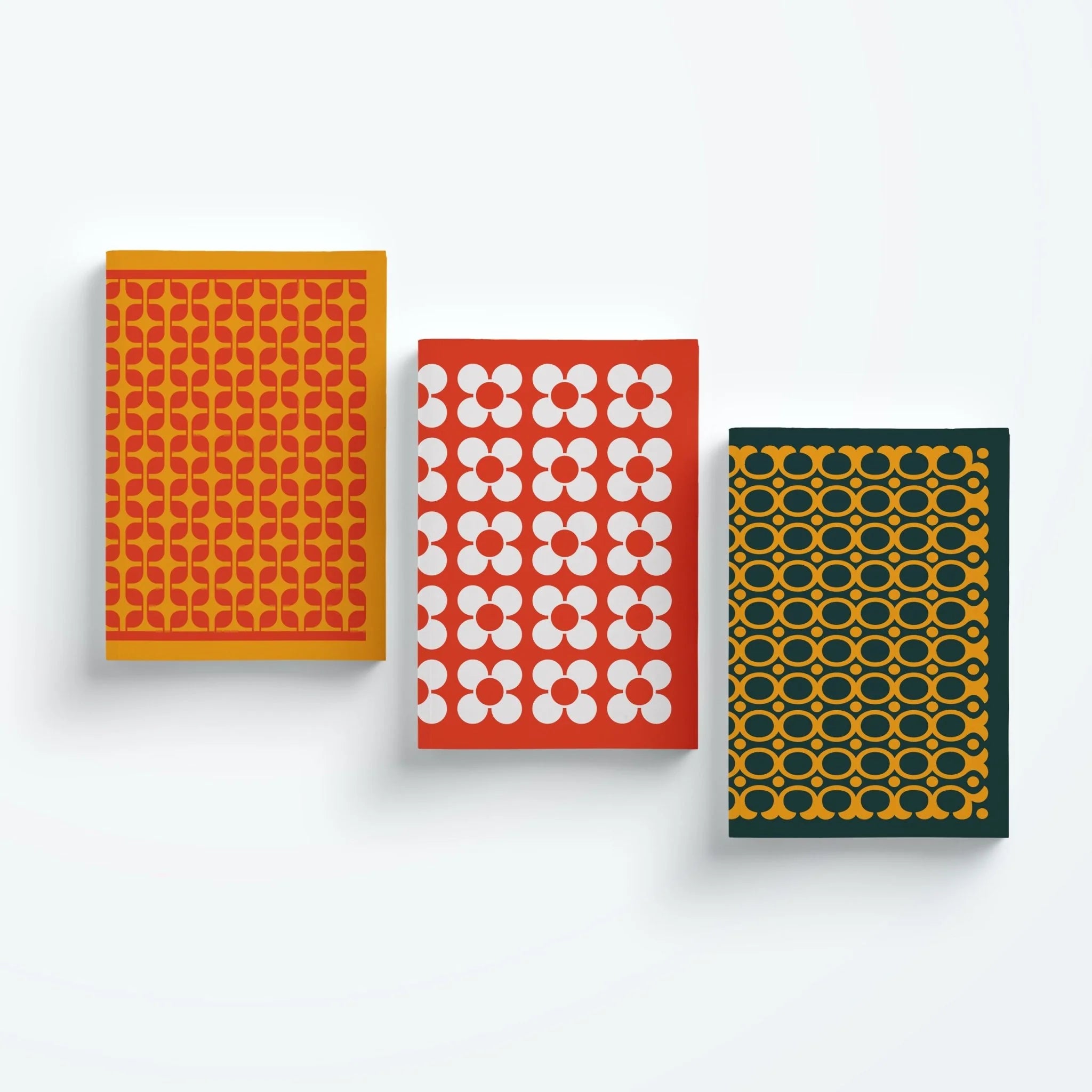 Three notebooks with different geometric patterns on a white background