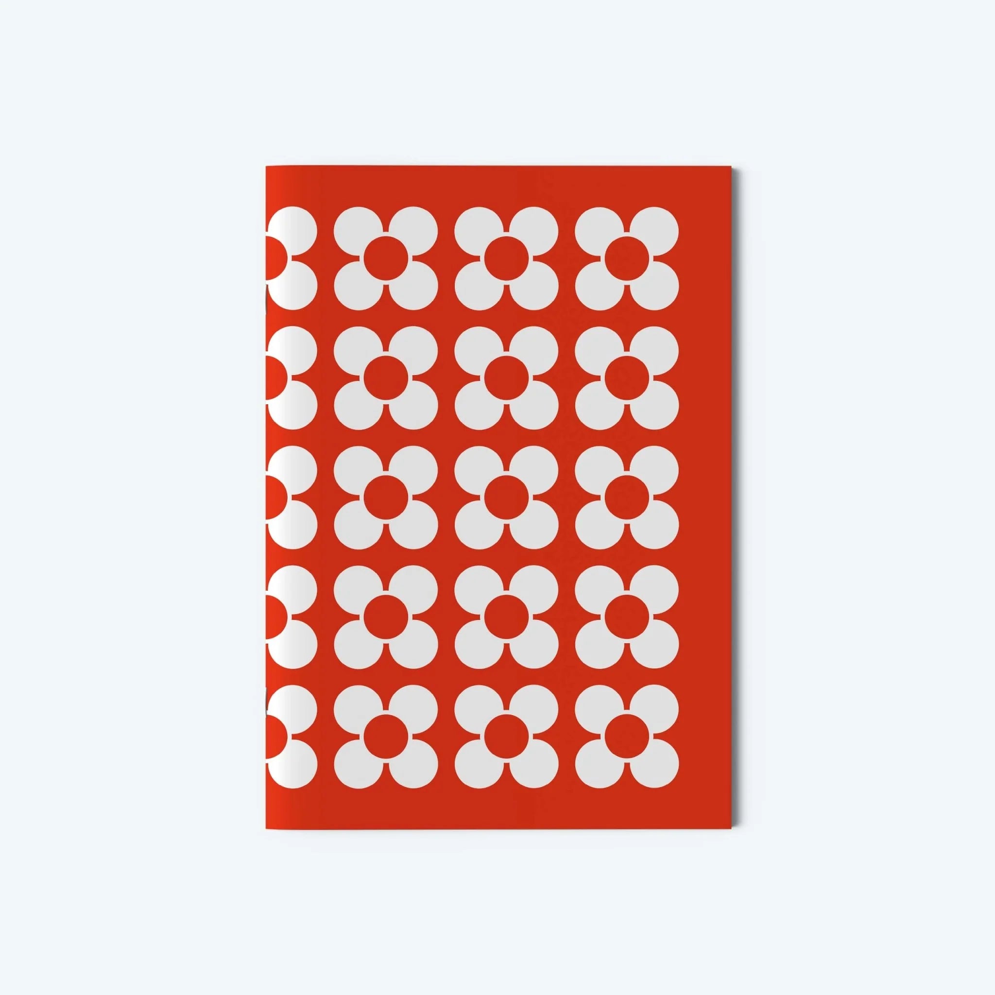 Red notebook with white floral pattern on a white background