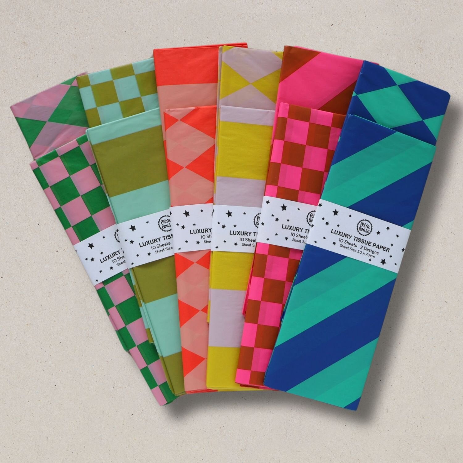 A stack of brightly colored tissue paper sheets with geometric patterns; each pack contains ten sheets in two designs.