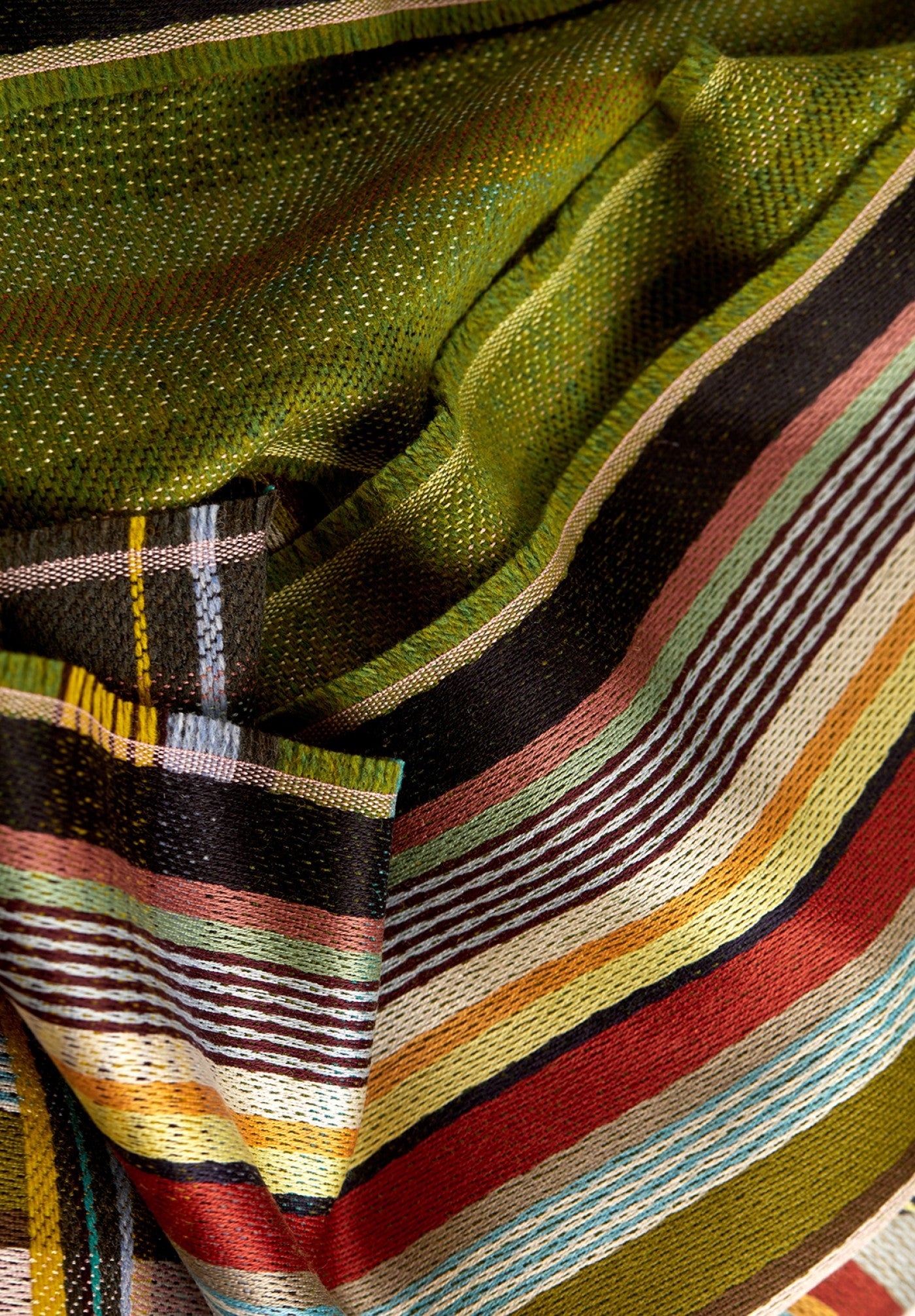 Close-up of a woven fabric with multicolored stripes and patterns.