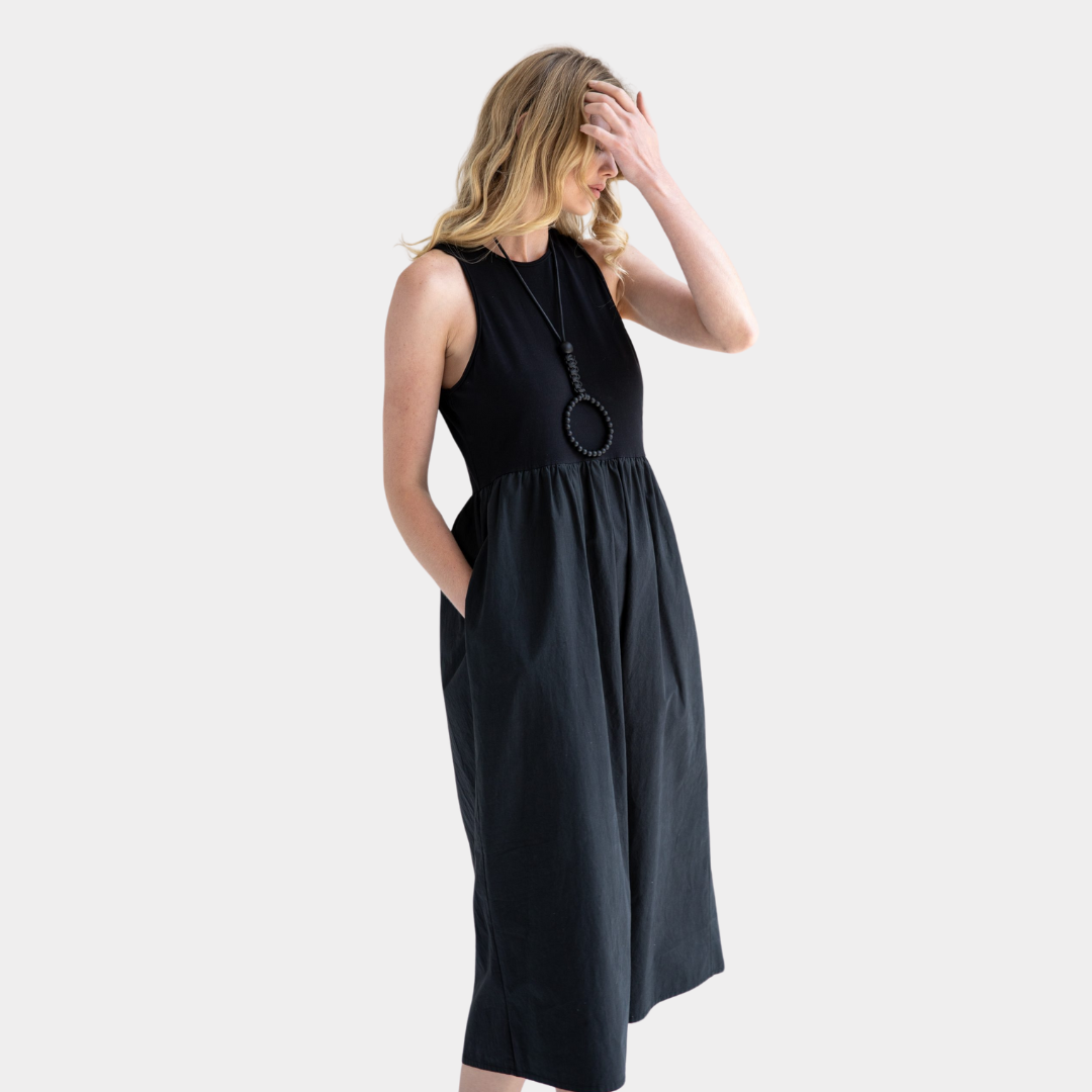 Black midi dress with a fitted bodice and a gathered skirt.  Features two pockets and a sleeveless design.