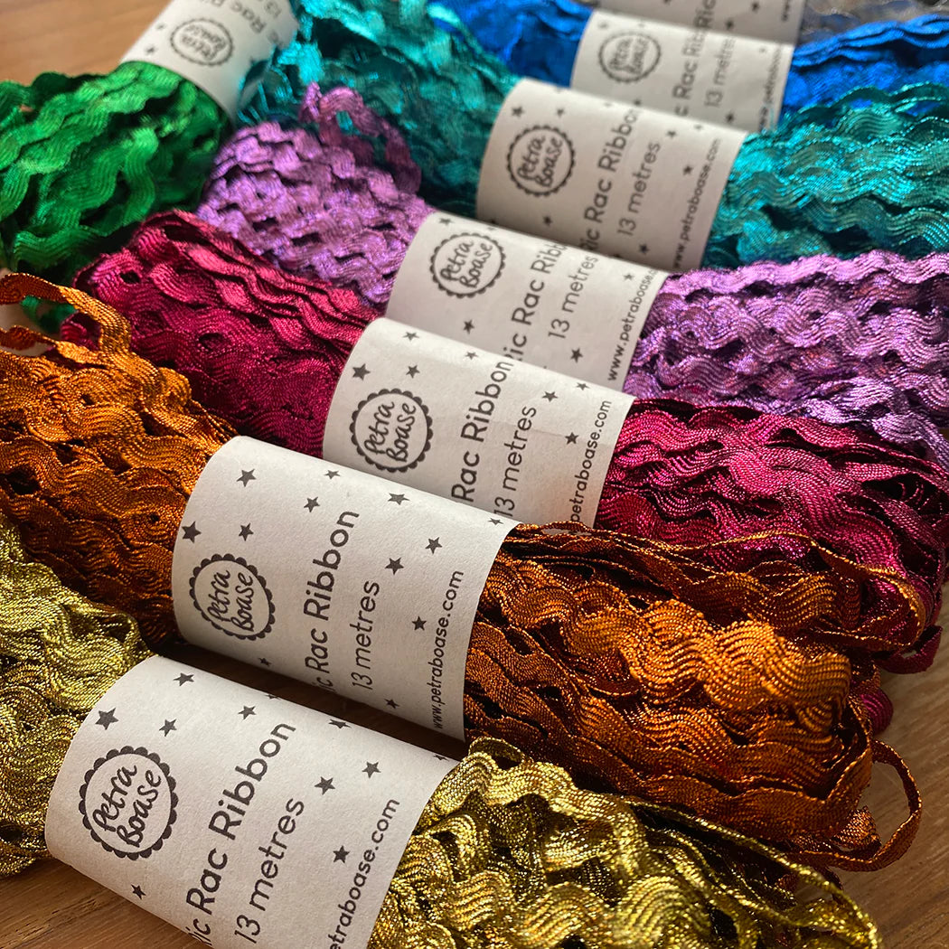 Assortment of metallic, wavy rac ribbon spools in various colors. Each spool contains 13 meters of ribbon.
