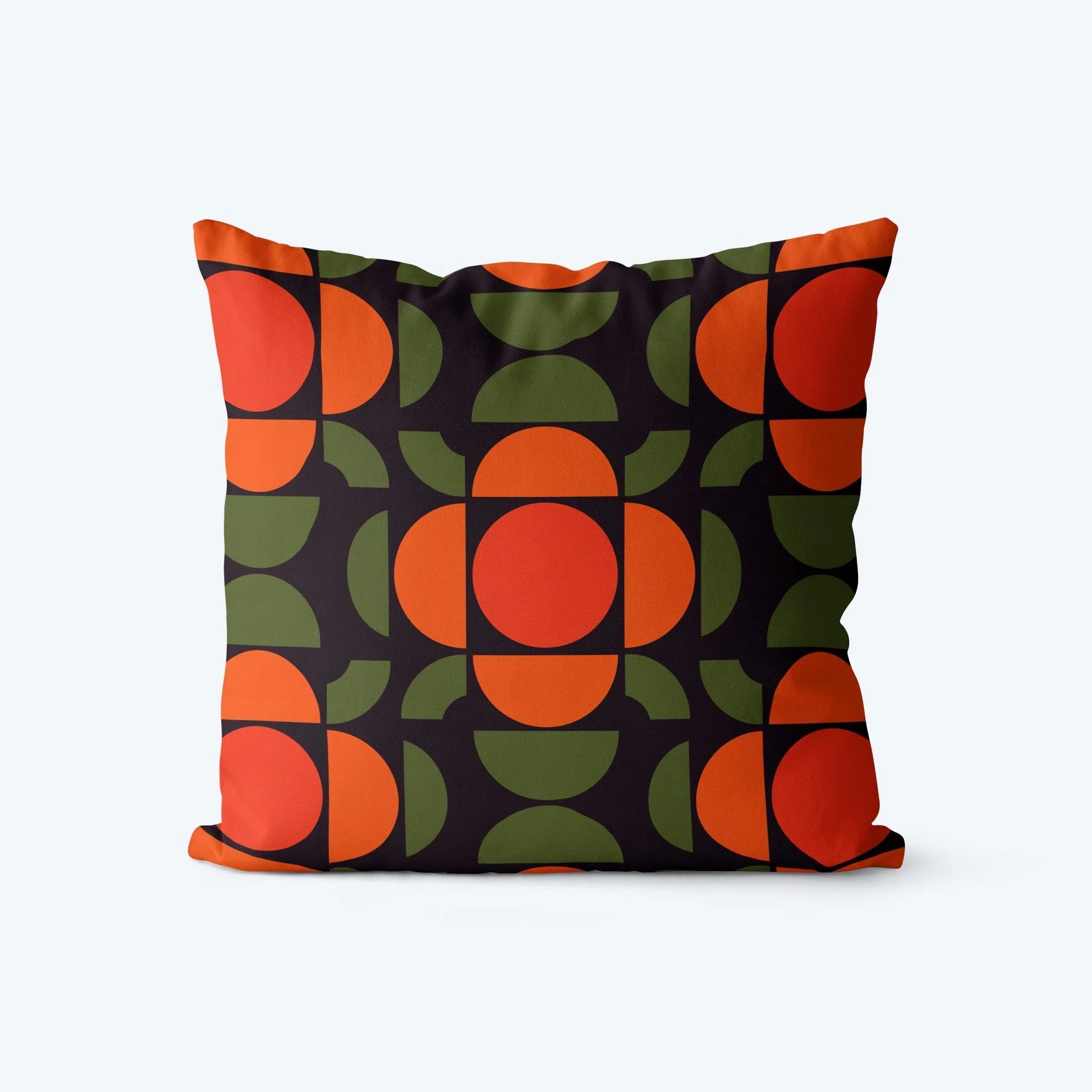 Decorative pillow with a geometric pattern of orange and green circles on a dark background
