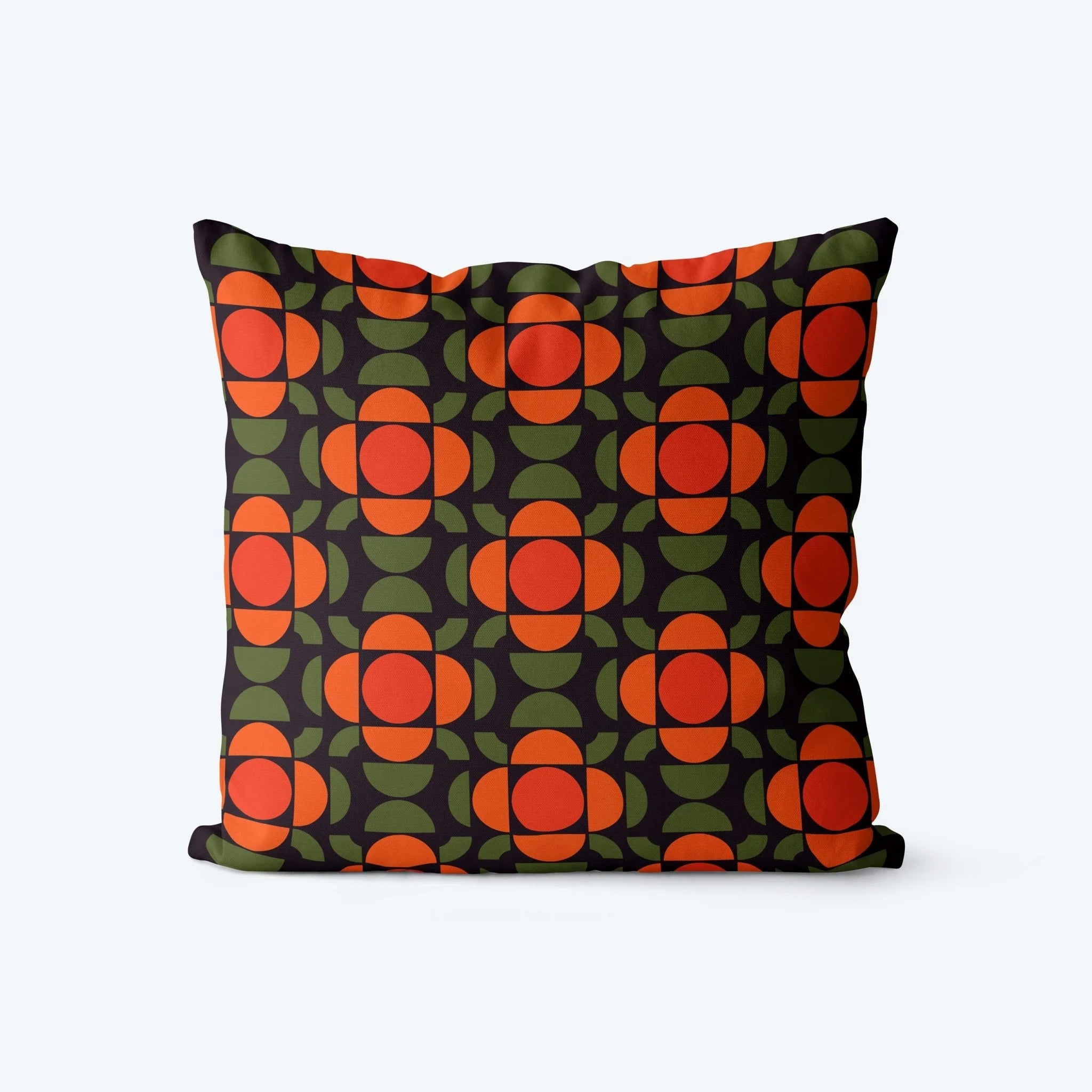 Decorative pillow with a geometric pattern of red and green shapes on a black background