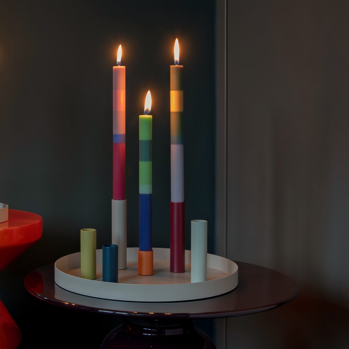 Colorful candles on a circular holder against a dark background