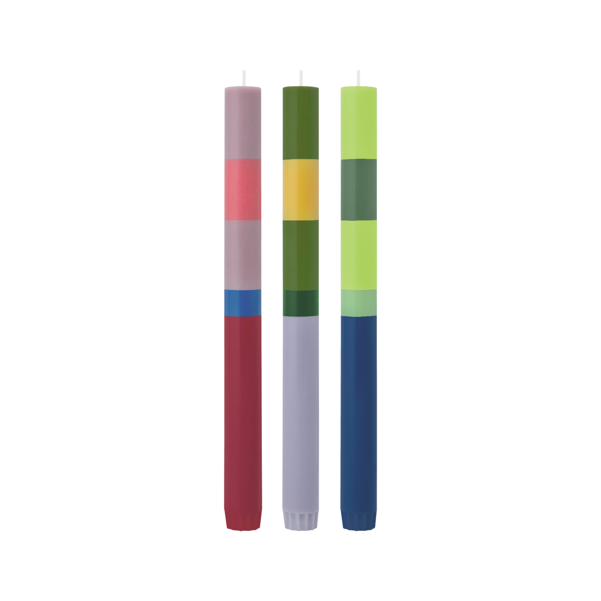 Three tall striped candles standing upright on a plain white background. The left candle has a lavender top, pink and light gray stripes, a blue band, and a dark red bottom.