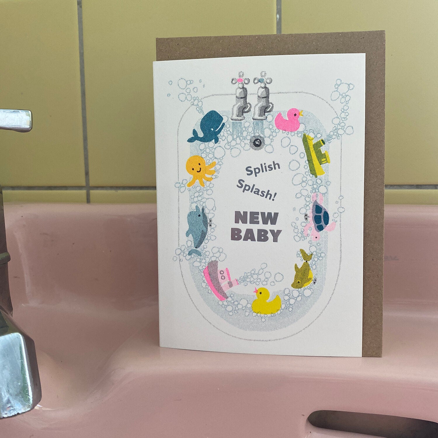 New baby greeting card featuring bath toys in a bathtub, text "Splish Splash! New Baby".