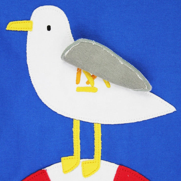 Seagull design on a blue background with a red and white life buoy