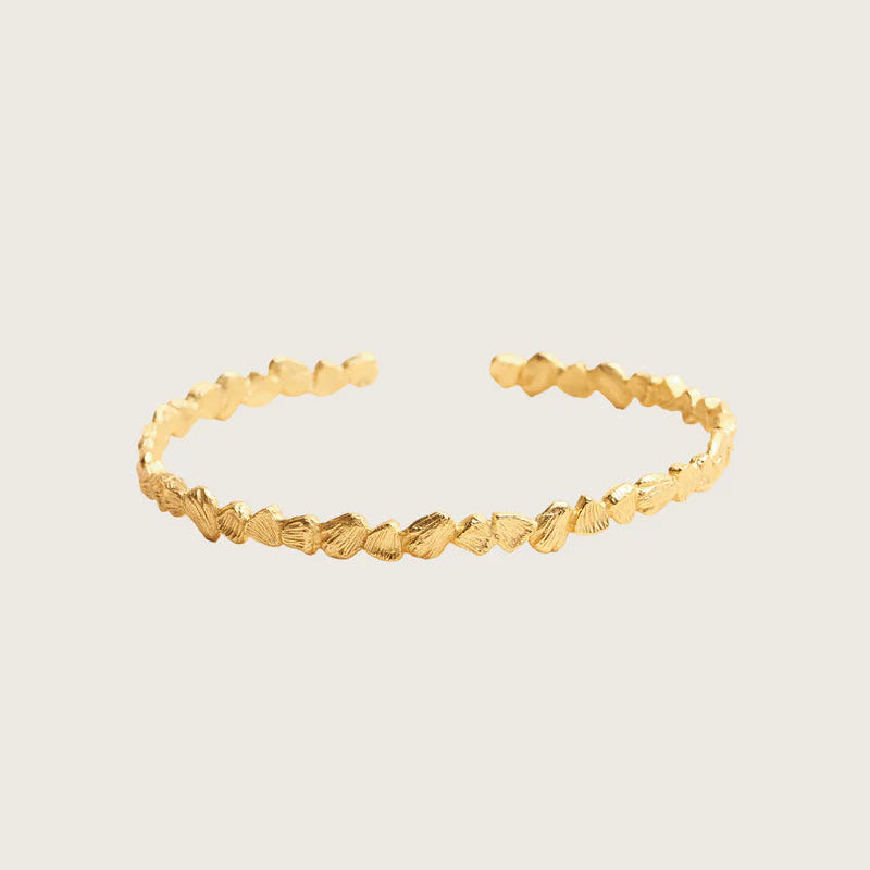 Gold bracelet on a light beige background