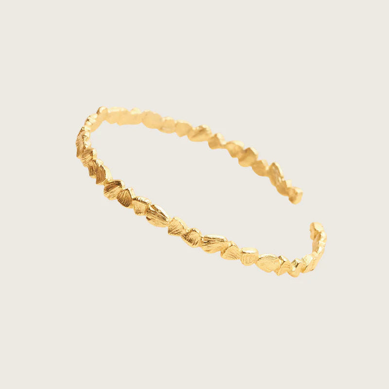Gold bracelet on a light beige background