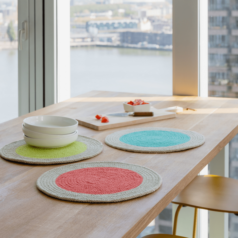 Three round placemats on a wooden table.