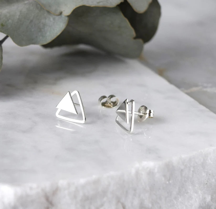 Pair of silver triangle stud earrings; one triangle is overlaid on another, creating a geometric design.