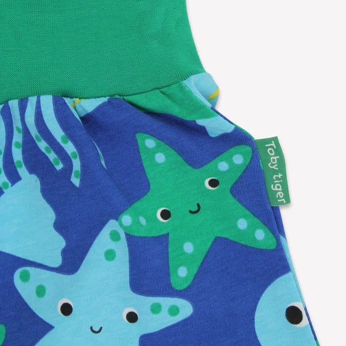 Children's pants with starfish pattern and green waistband on a white background