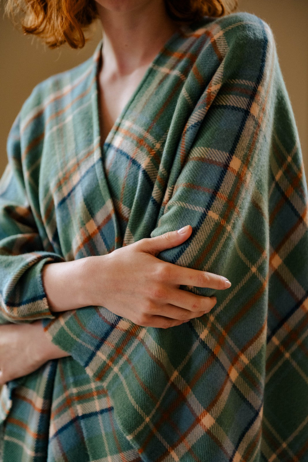 Person wearing a green plaid robe with a neutral background