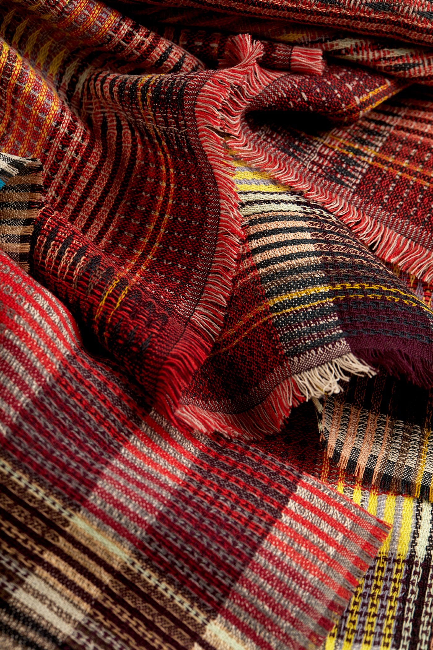 Close-up of patterned fabric with red, brown, and yellow colors.