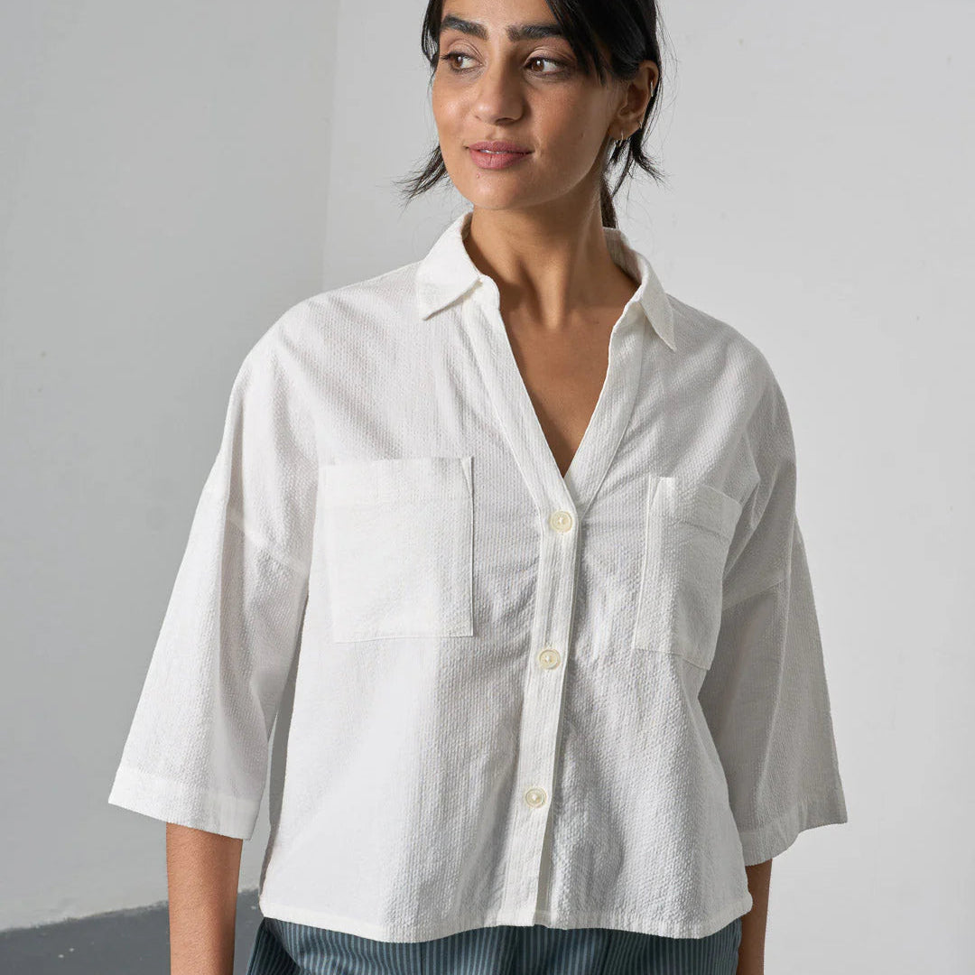 Woman wearing a white shirt with a gray background