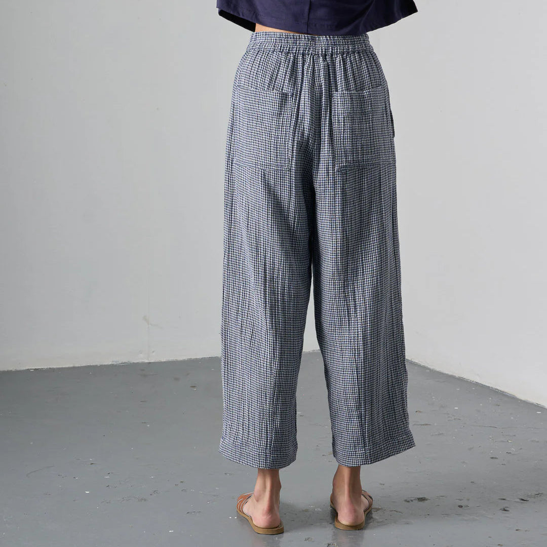 Person wearing blue checkered pants against a plain background