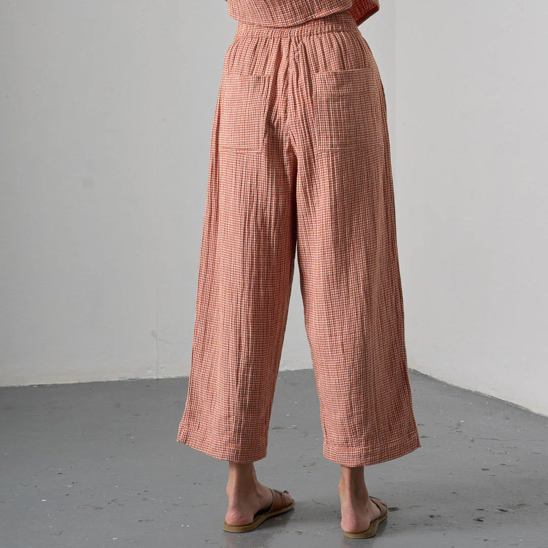 Person wearing a pink checkered outfit against a plain background