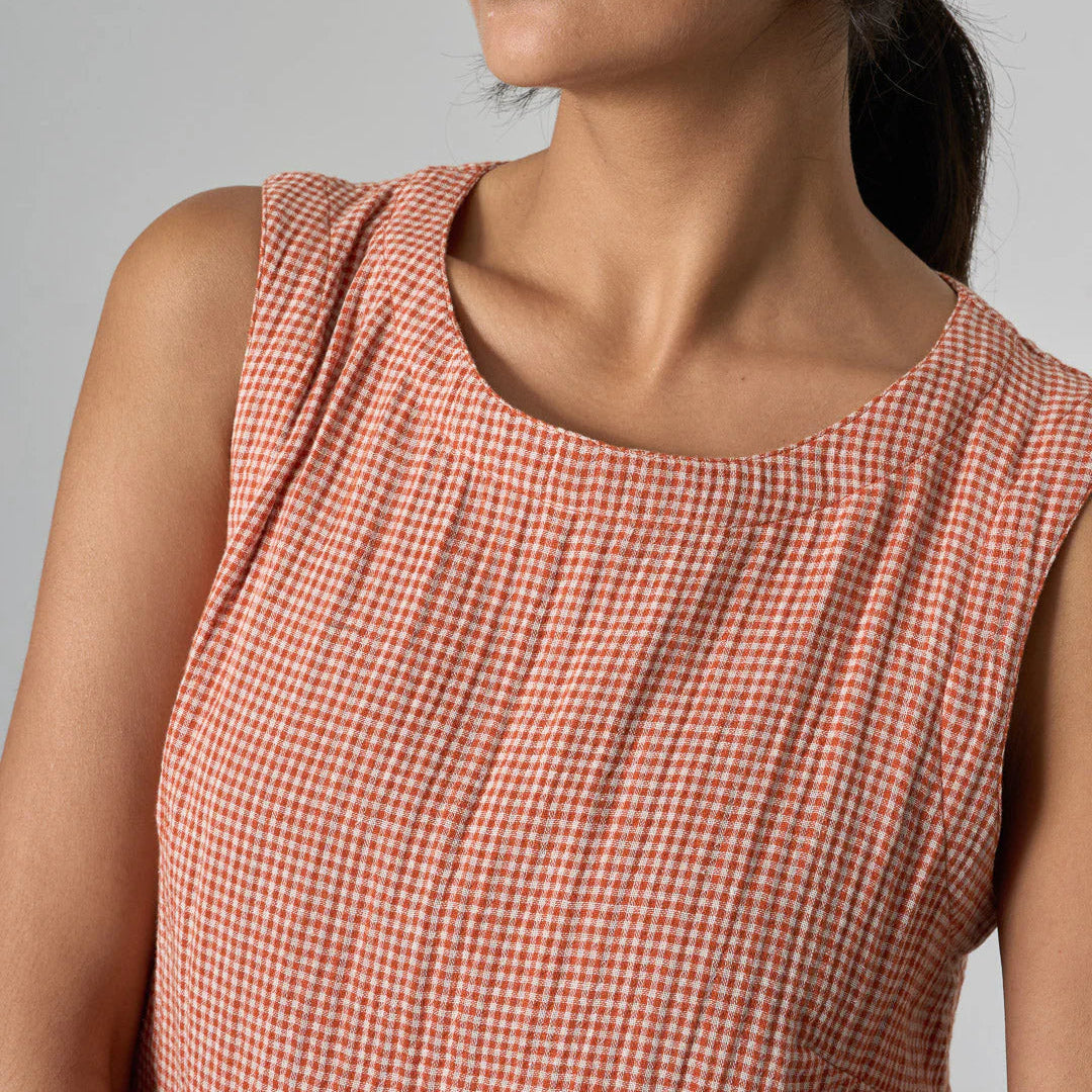 Woman wearing a red and white checkered dress against a gray background