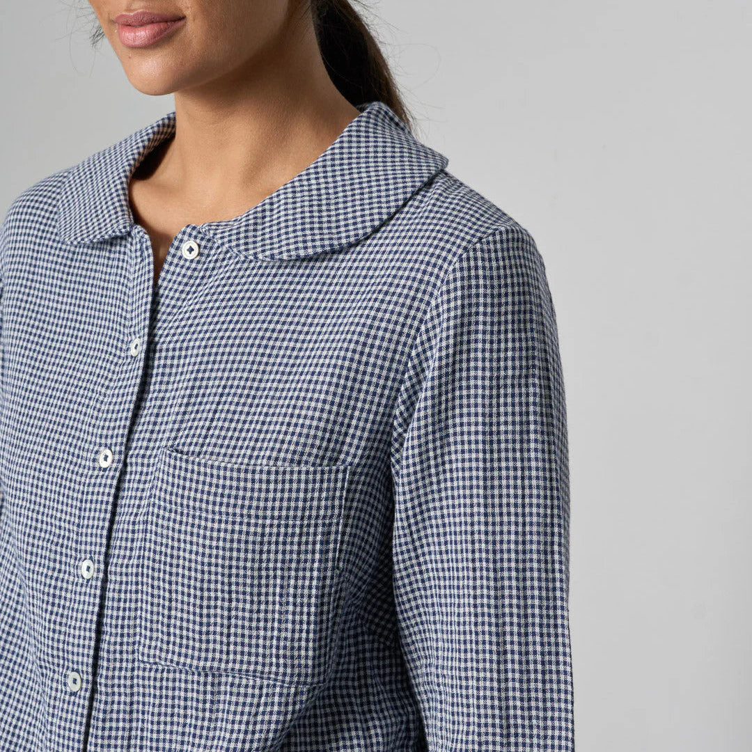 Person wearing a blue and white checkered shirt against a gray background