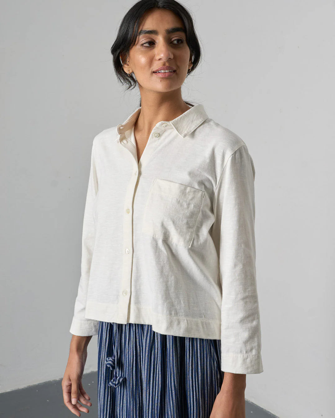 Woman wearing a white shirt with a neutral background