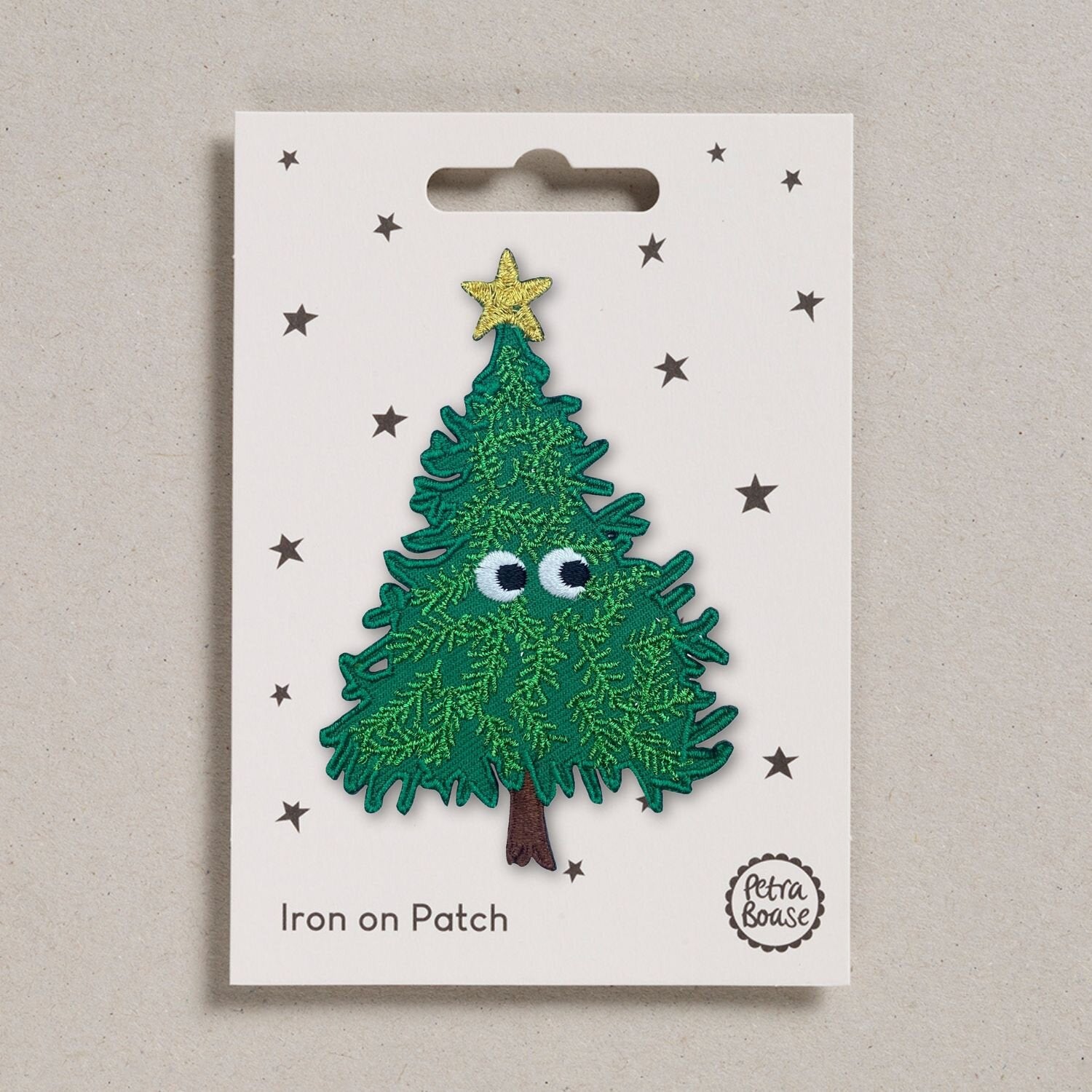 Green embroidered Christmas tree iron-on patch with googly eyes and a gold star.