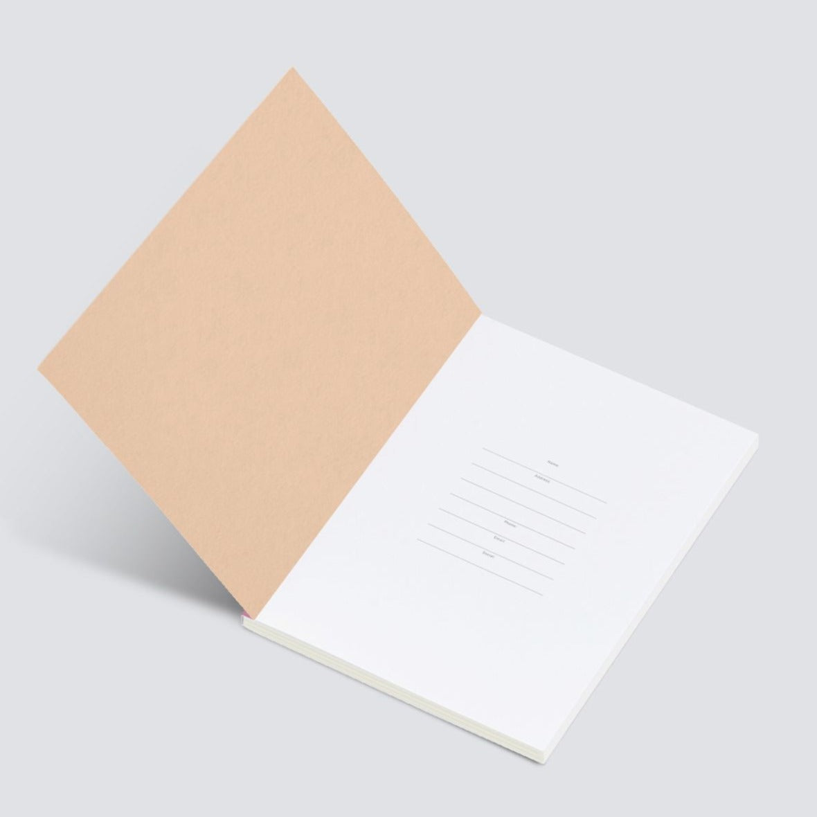 Partially open notebook with a light peach-colored cover and blank white pages;  interior pages feature simple lined address