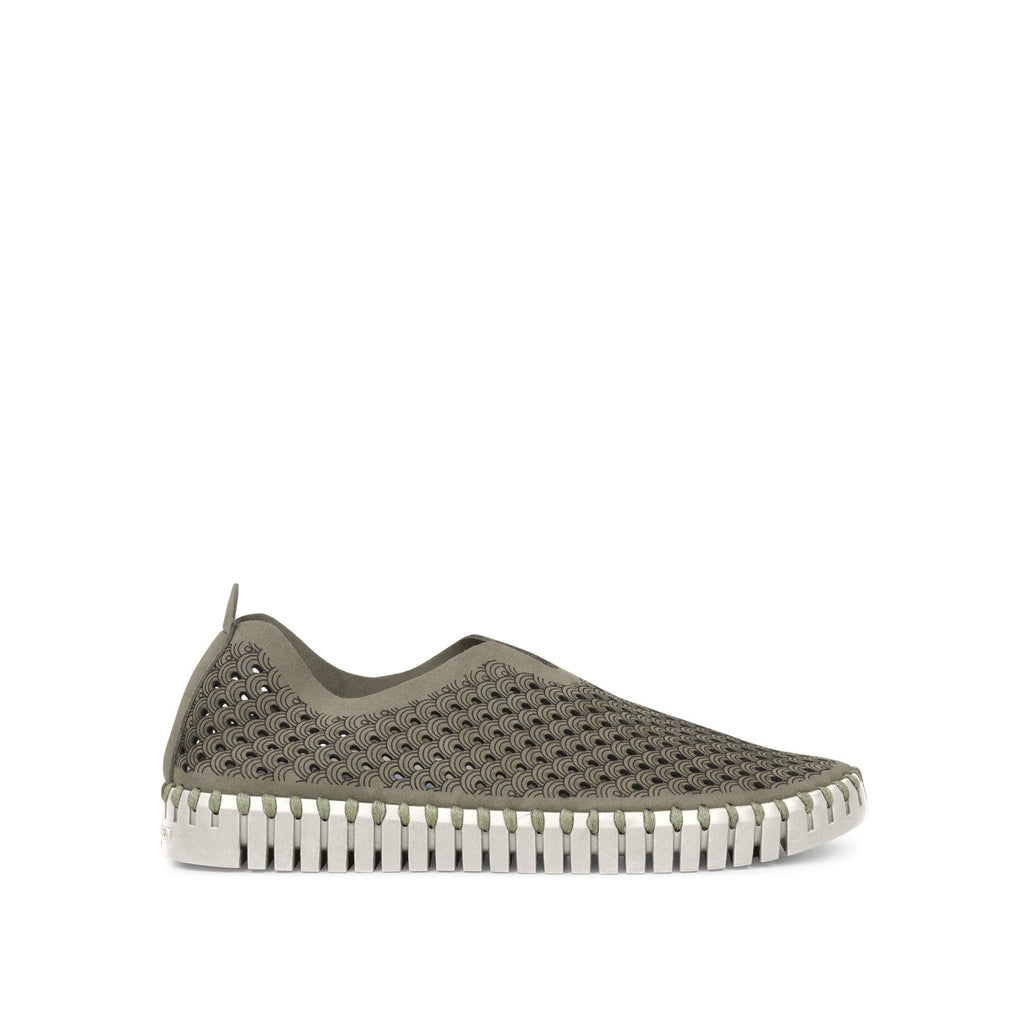 Olive green slip-on shoe with a textured, patterned upper and a unique, ridged white sole. Darker olive pattern is subtly