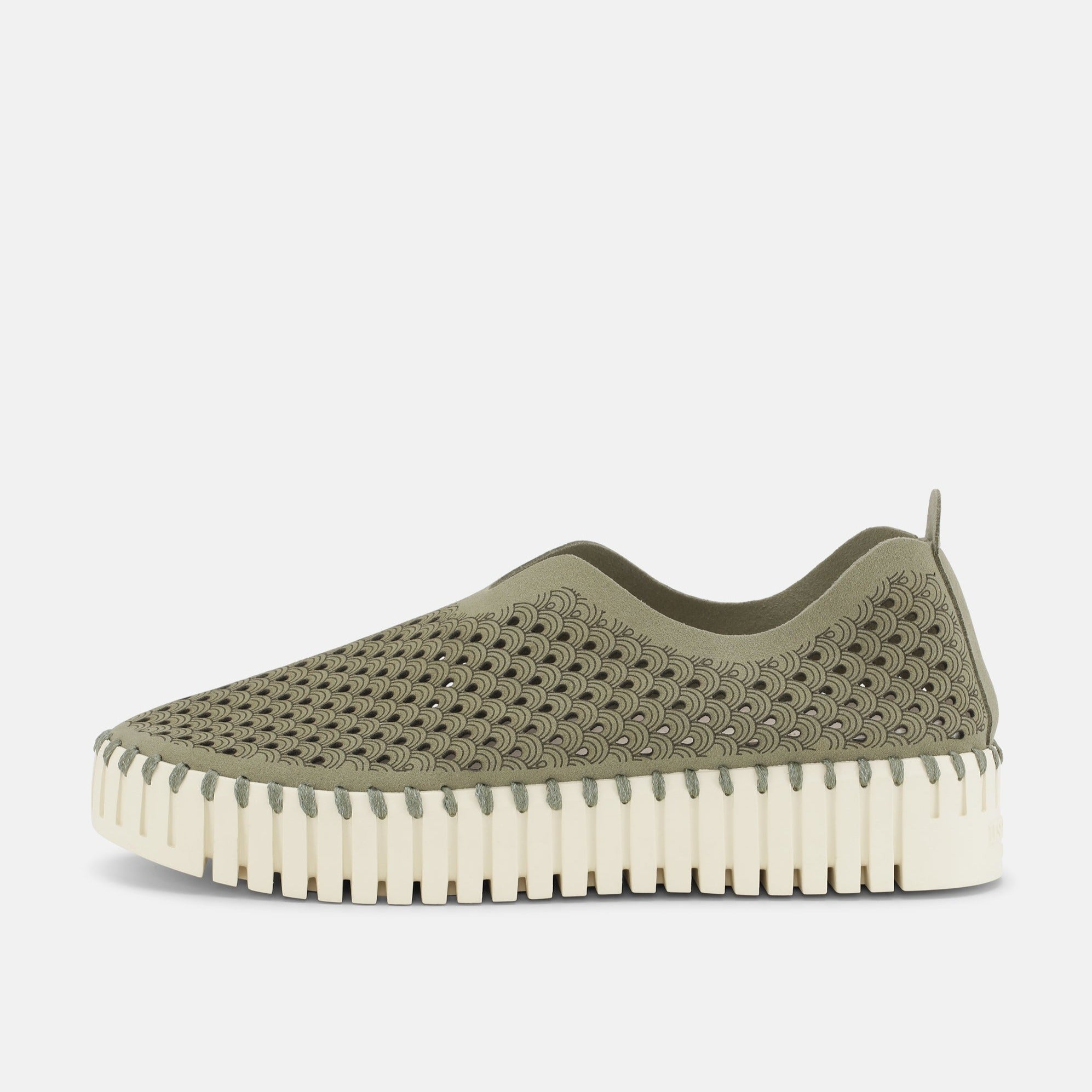 Olive green slip-on shoe with a cream-colored, ridged sole and a textured, patterned upper.