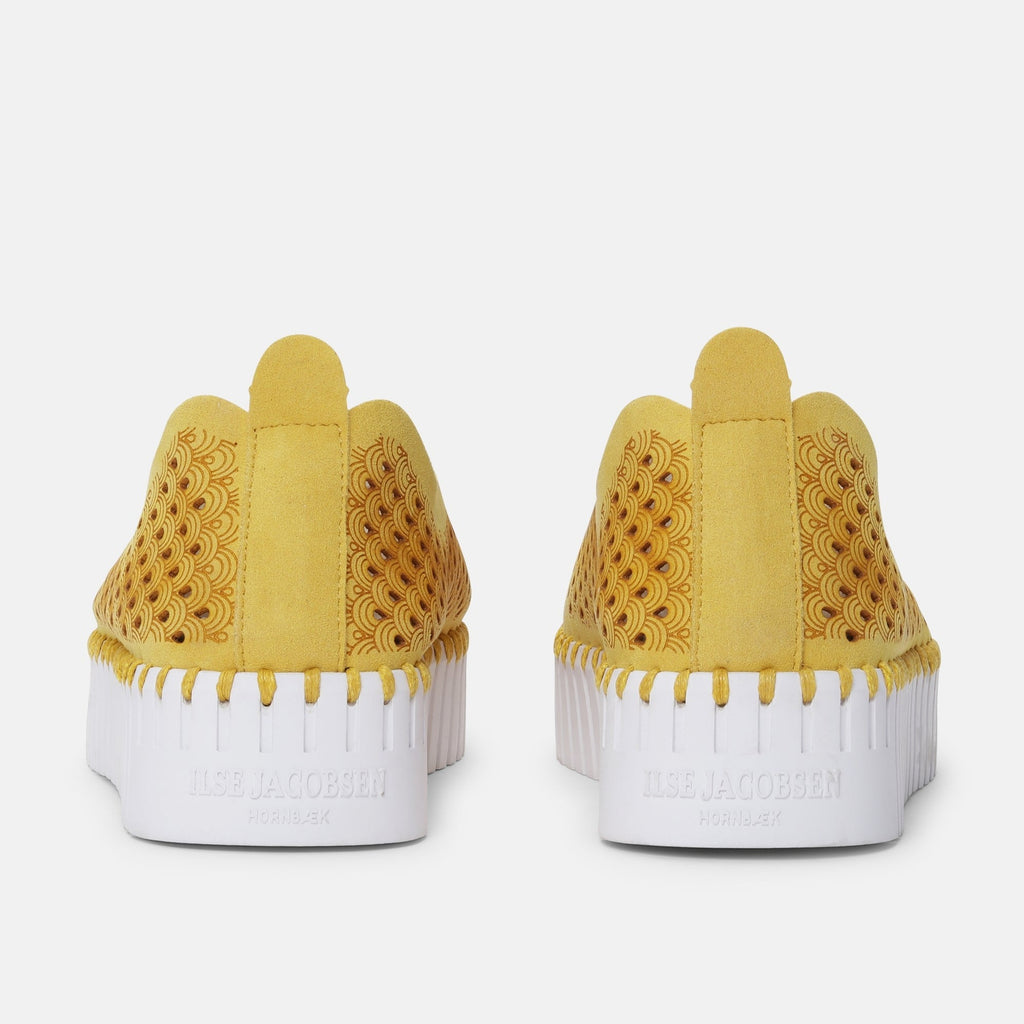 Ilse Jacobsen Hornbæk yellow suede slip-on shoes with intricate laser-cut pattern and white platform sole.