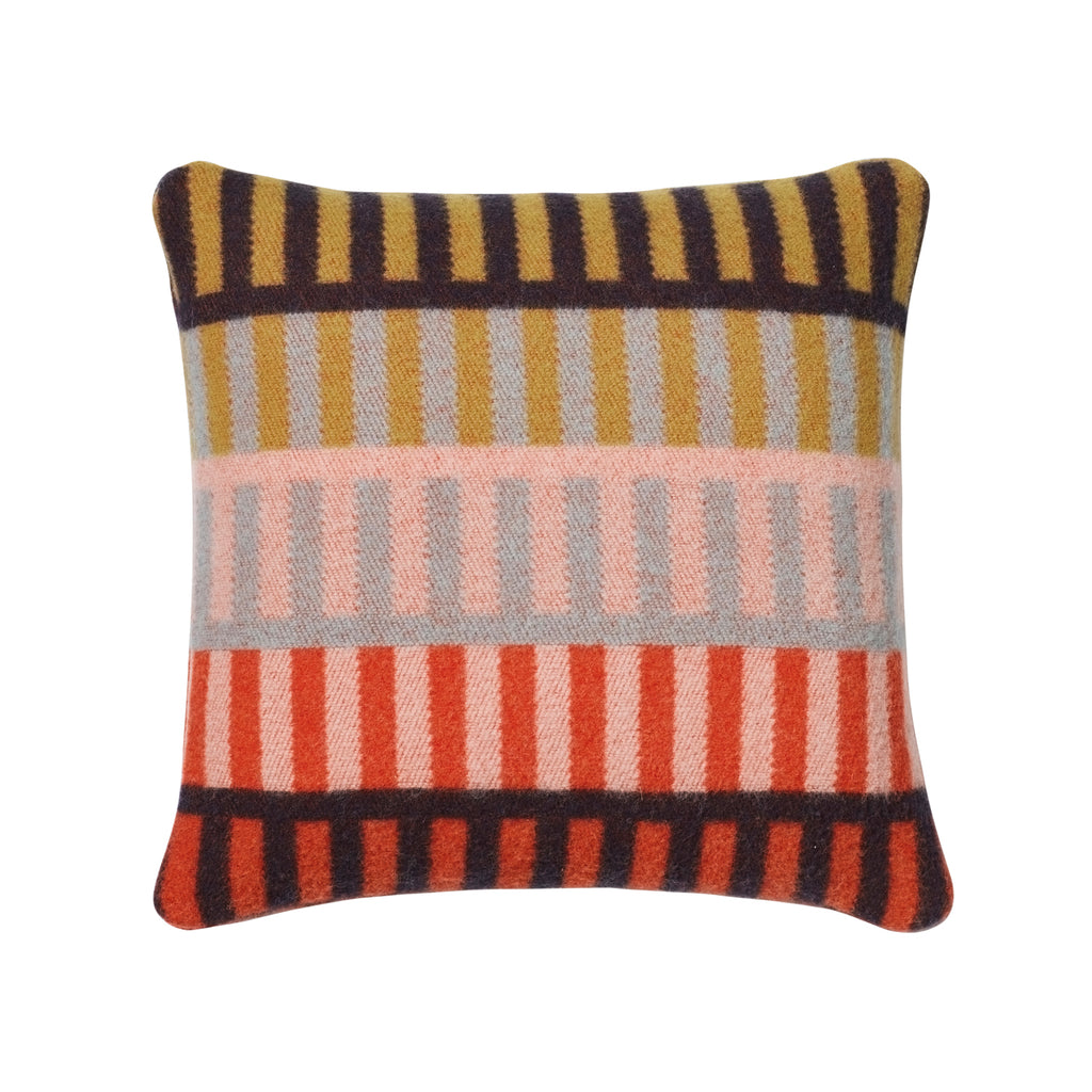 Colorful striped cushion by Donna Wilson, featuring gold, gray, pink, and red stripes on a soft texture.