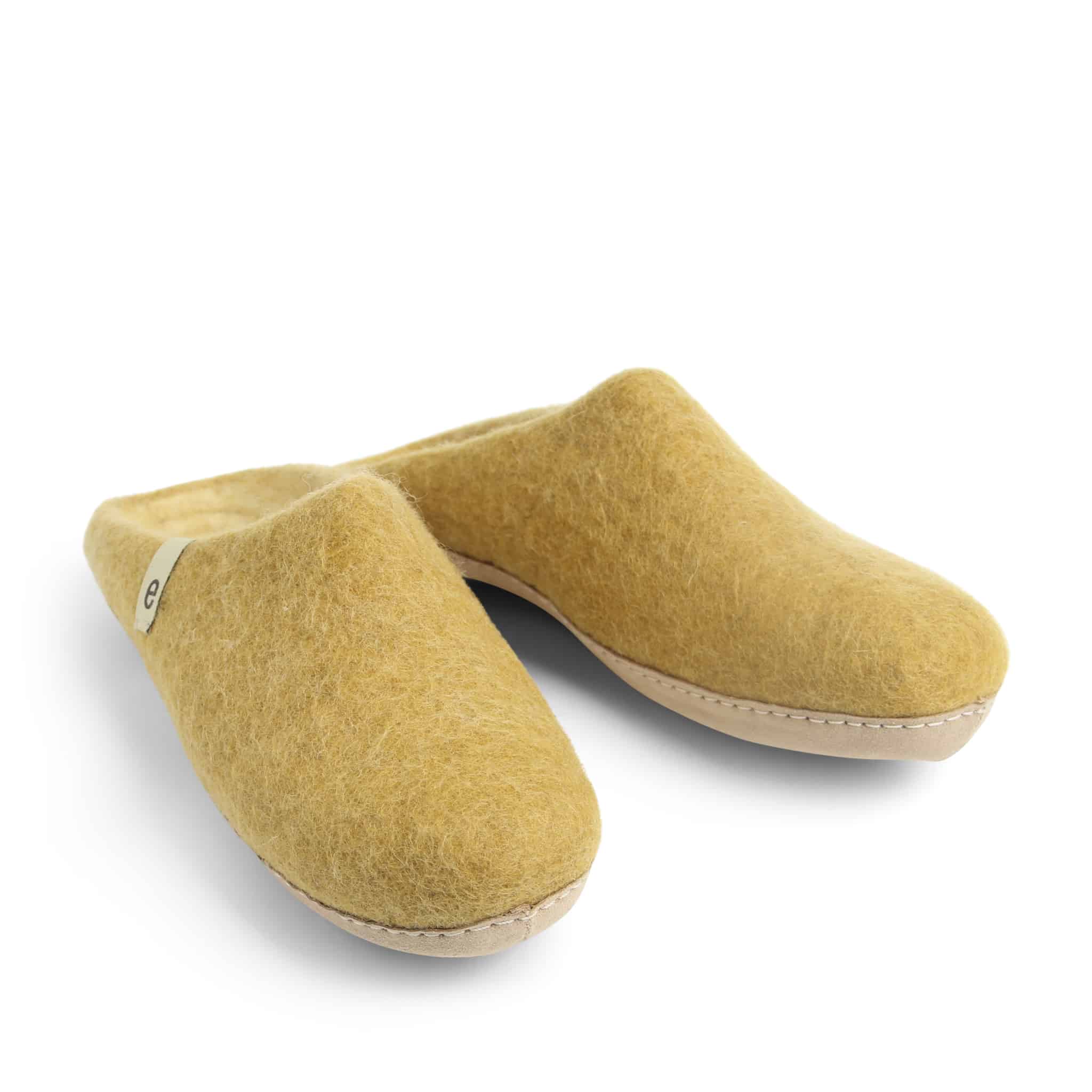 Pair of mustard-yellow wool felt slippers with light beige soles.  Small label on one slipper.