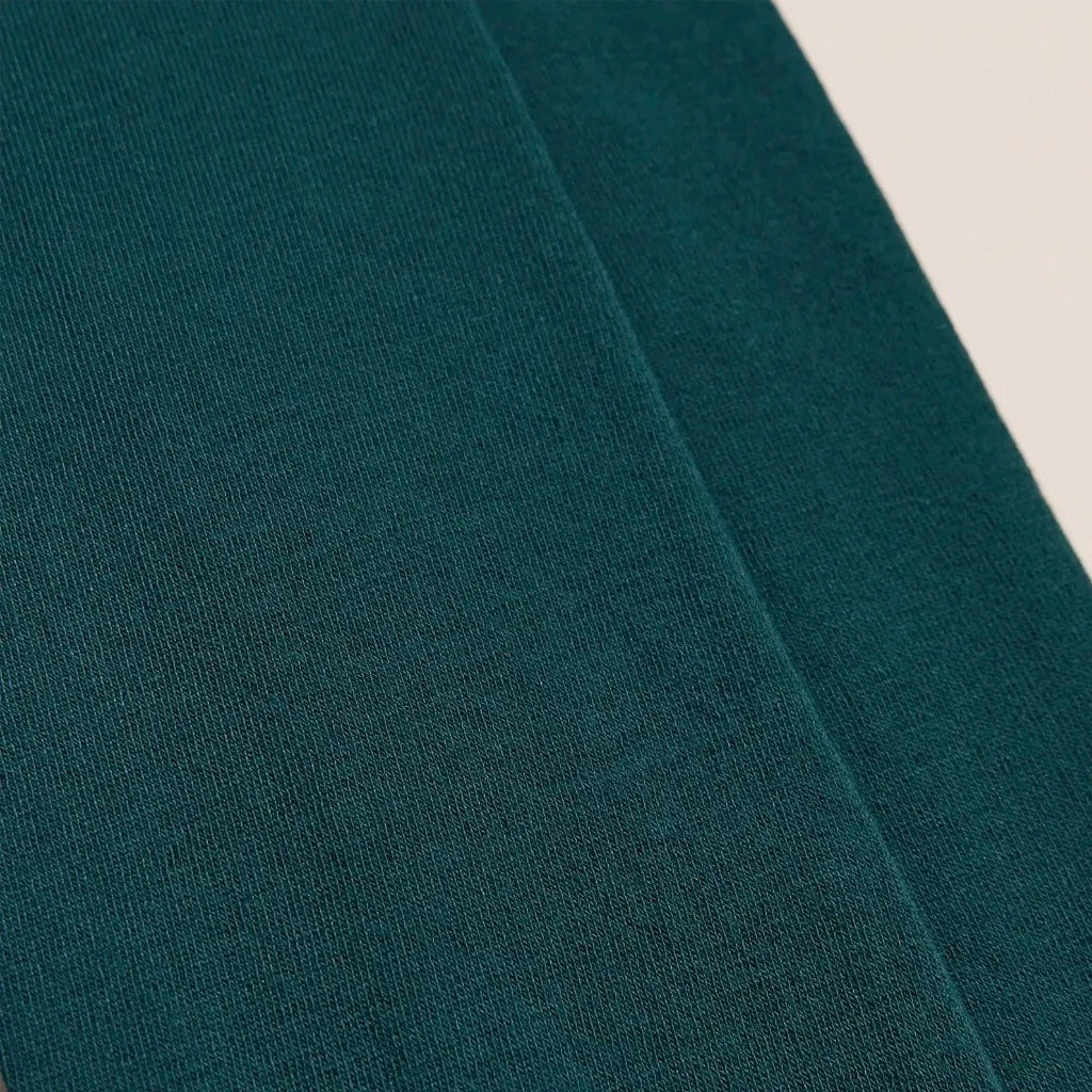 Close-up of dark teal fabric with a slightly textured surface.
