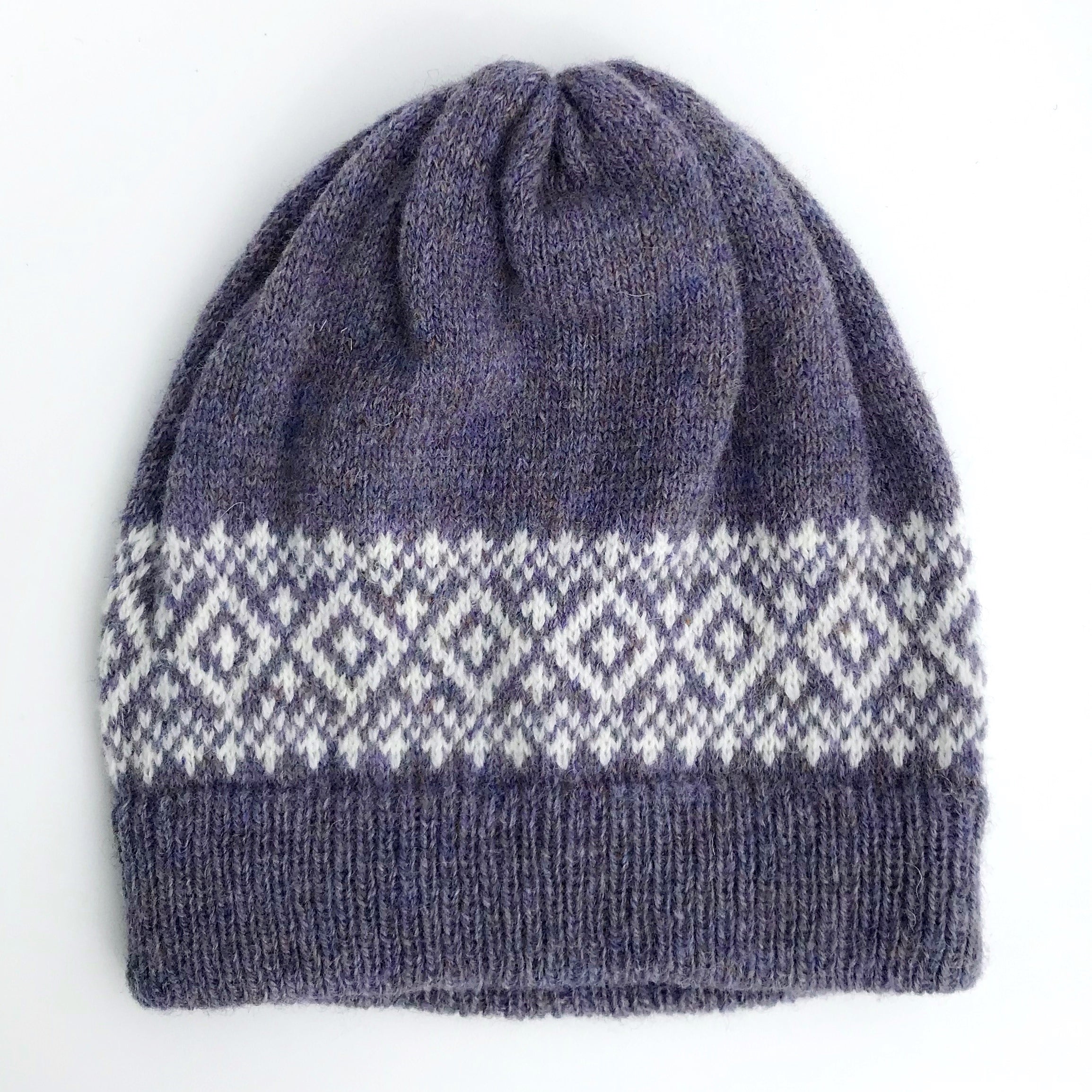 Hand-knitted beanie in dark gray with a white diamond pattern band.