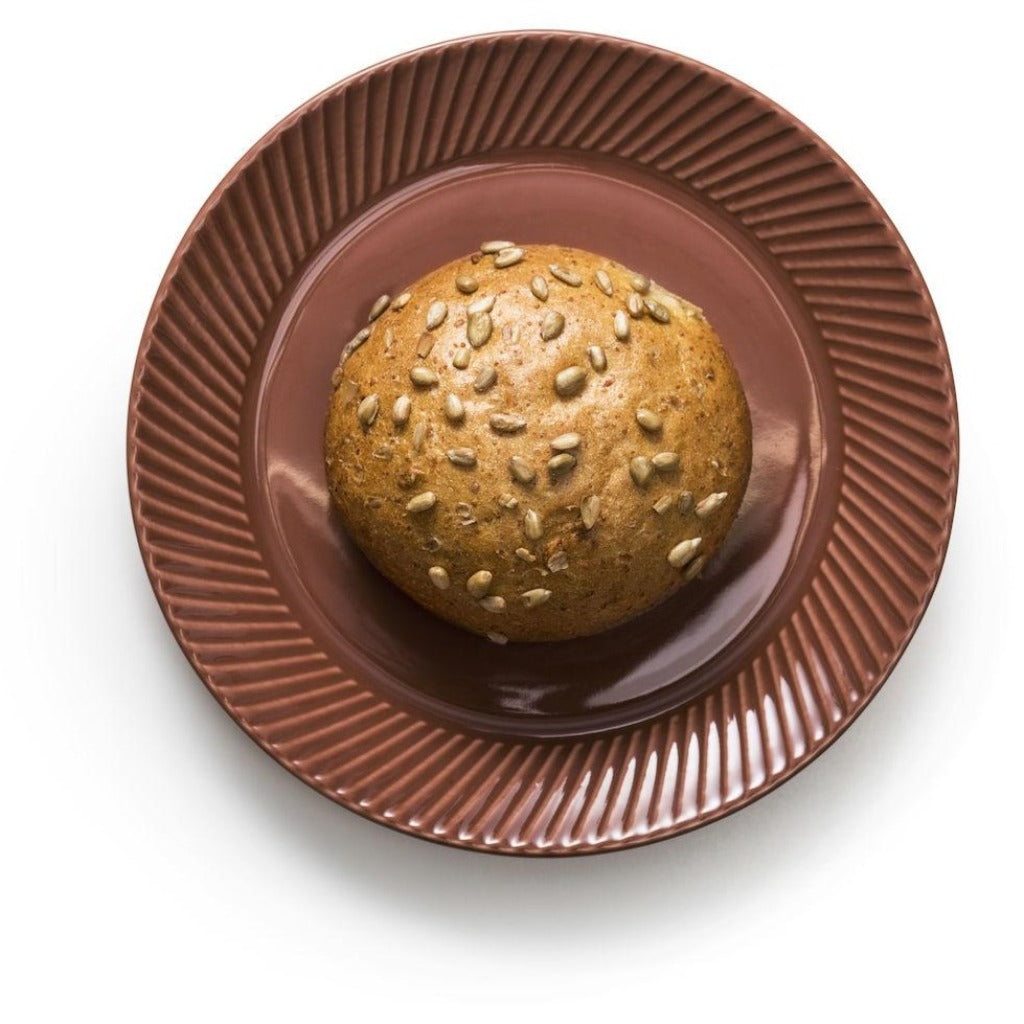 Sunflower seed bread roll on a brown plate.