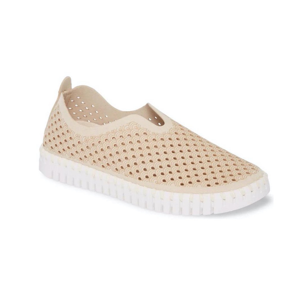 Beige slip-on shoe with a white sole, featuring a textured, perforated upper with a repeating wave pattern.
