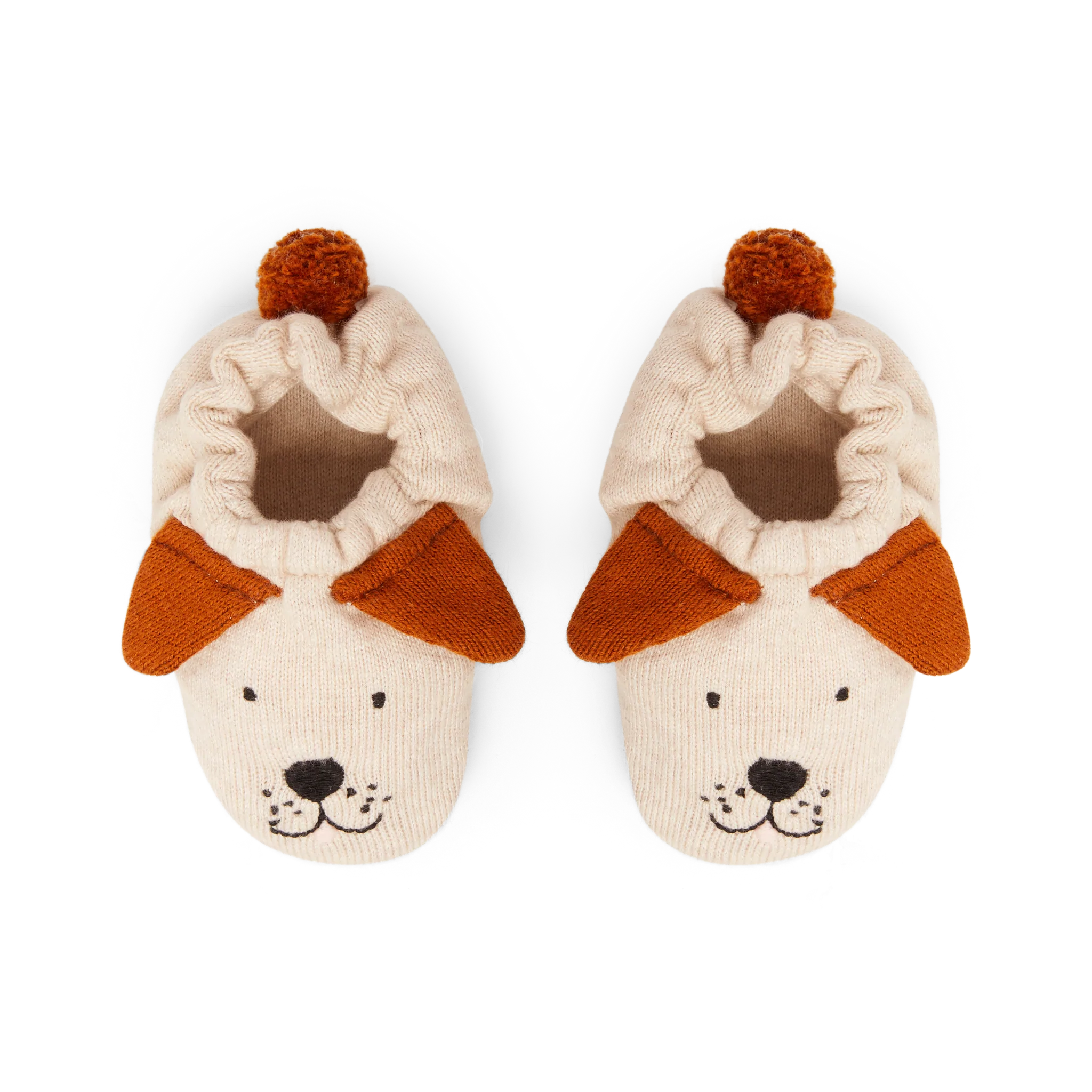 Pair of beige knitted baby booties with brown felt dog ears and faces, topped with small brown pom-poms.