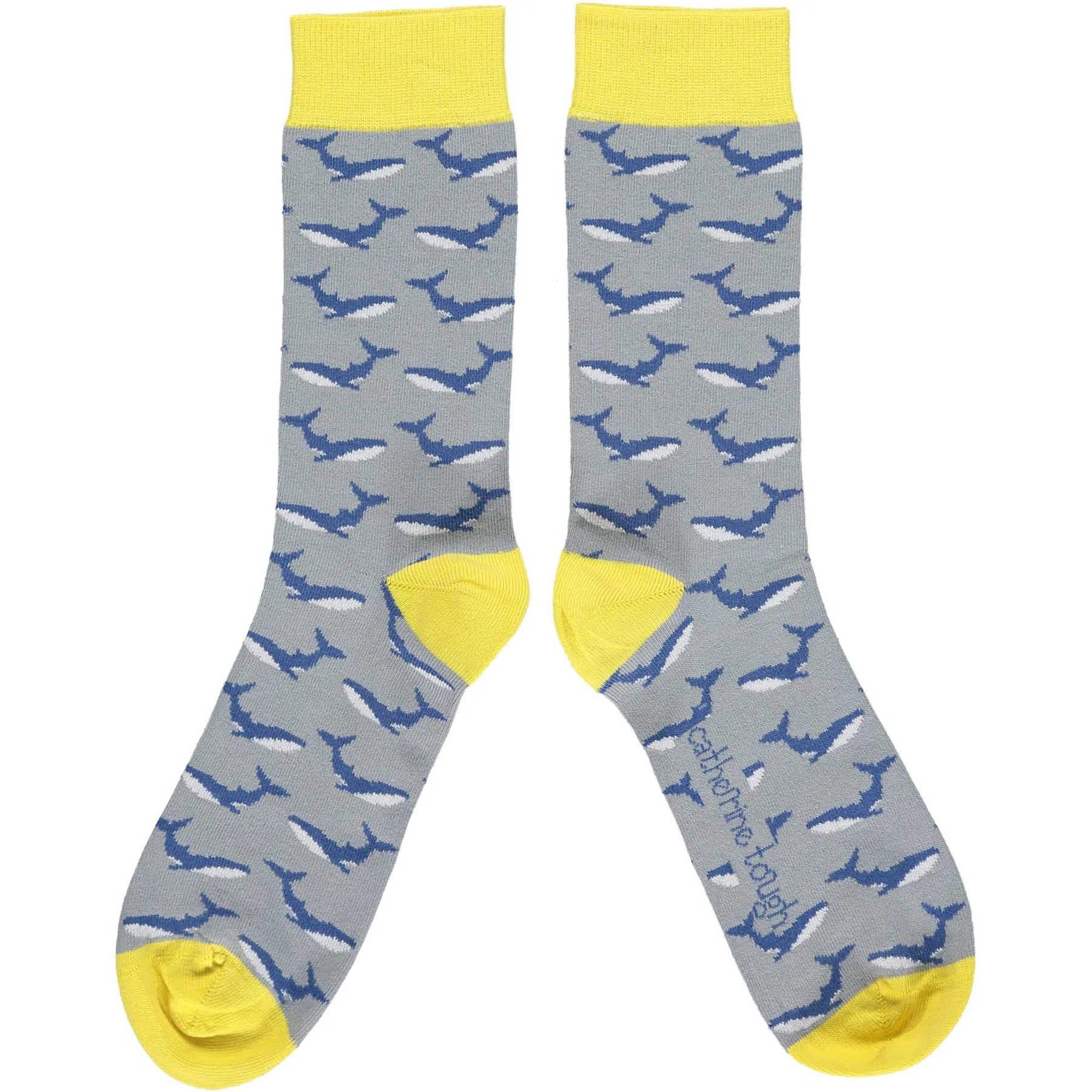 Pair of grey socks with a repeating pattern of blue whales and yellow cuffs.