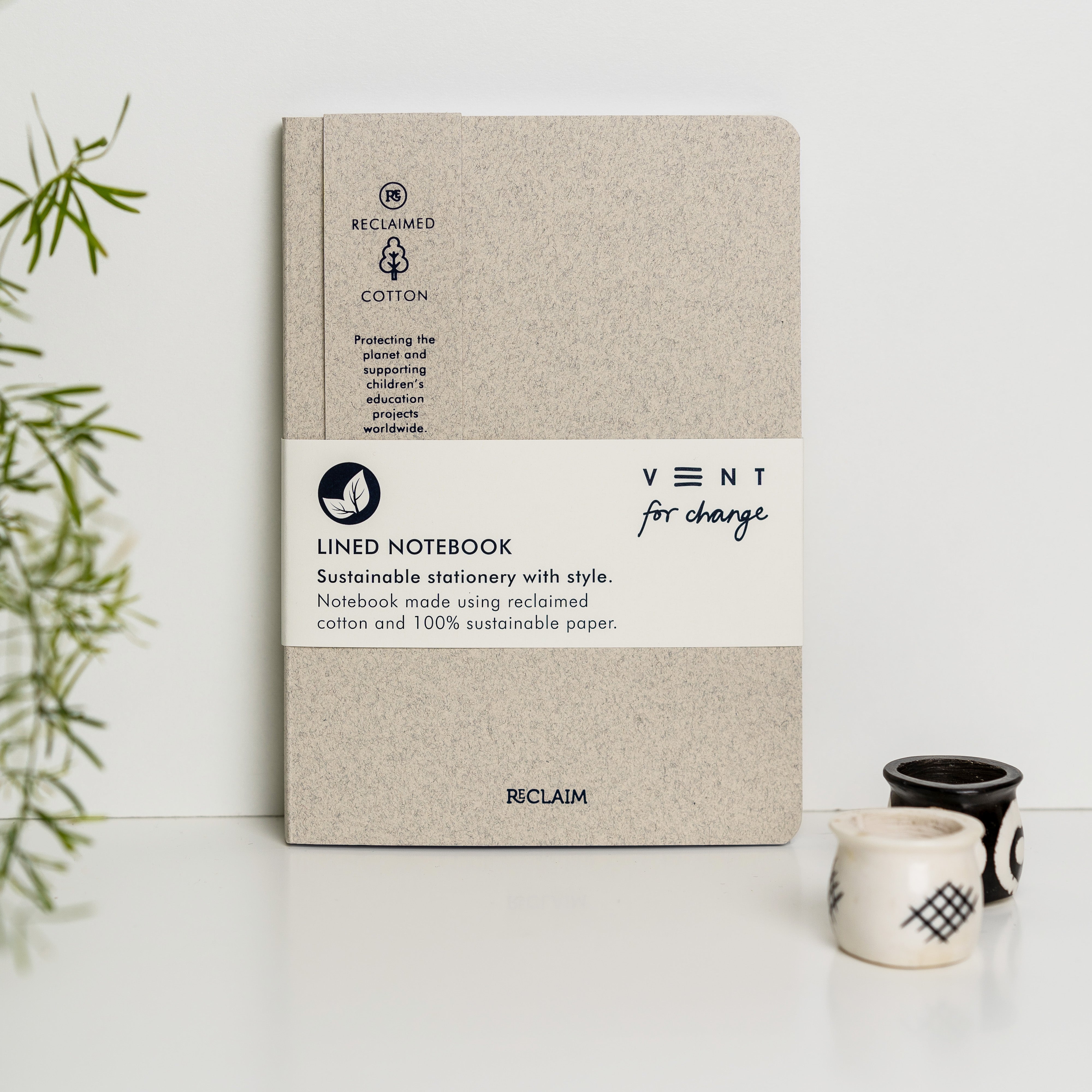 Beige lined notebook made with reclaimed cotton and sustainable paper.  Features "VENT for change" branding.