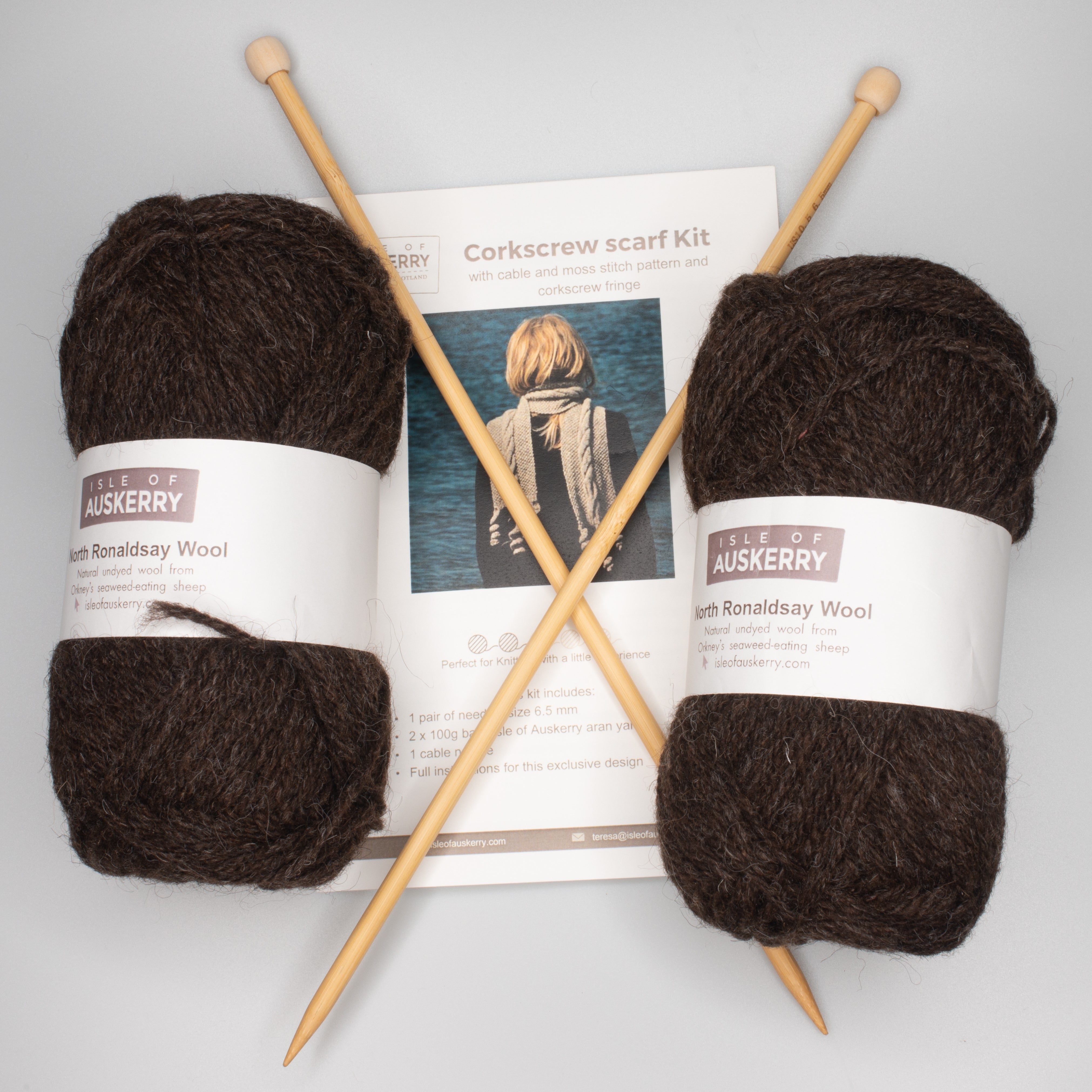 Corkscrew scarf knitting kit with two balls of dark brown North Ronaldsay wool and a pair of bamboo knitting needles.