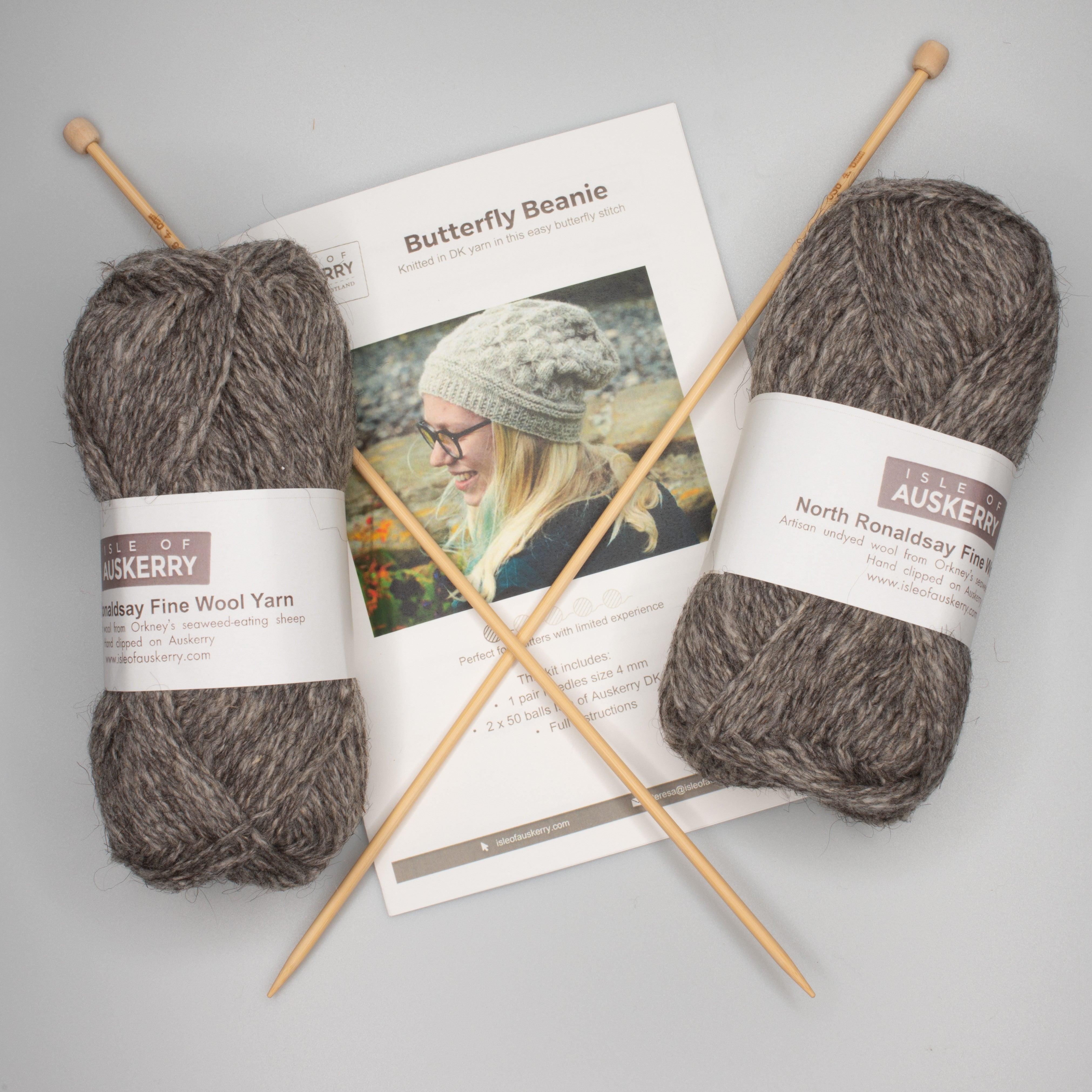 Knitting kit with two balls of grey North Ronaldsay Fine Wool yarn, a pair of 4mm knitting needles, and instructions for a