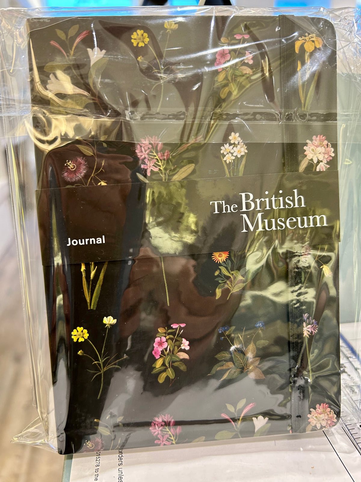 Black journal with floral print, featuring various flowers and foliage on a dark background.