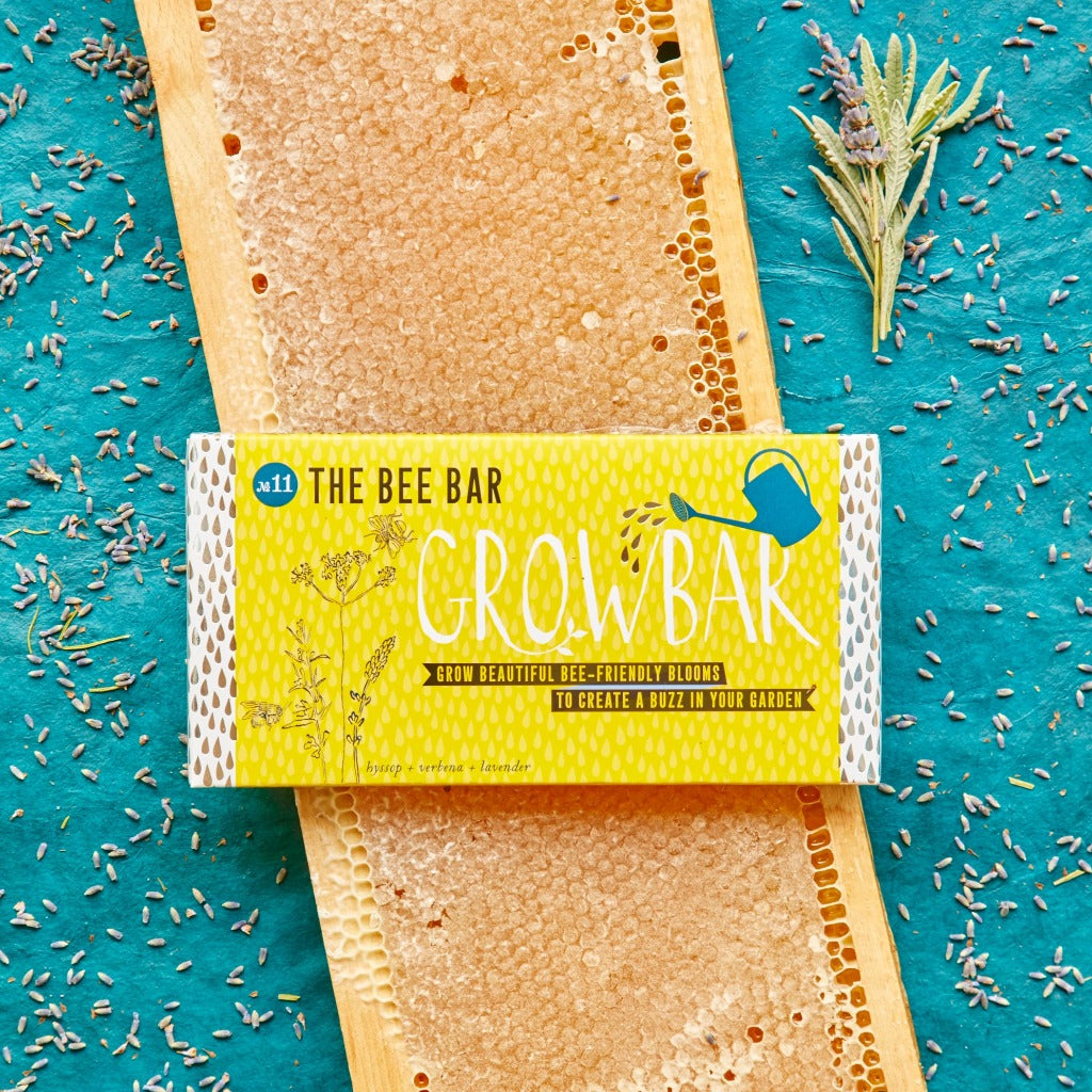 Yellow box labeled "The Bee Bar Grow Bar," showing bee-friendly flower seeds for gardening.