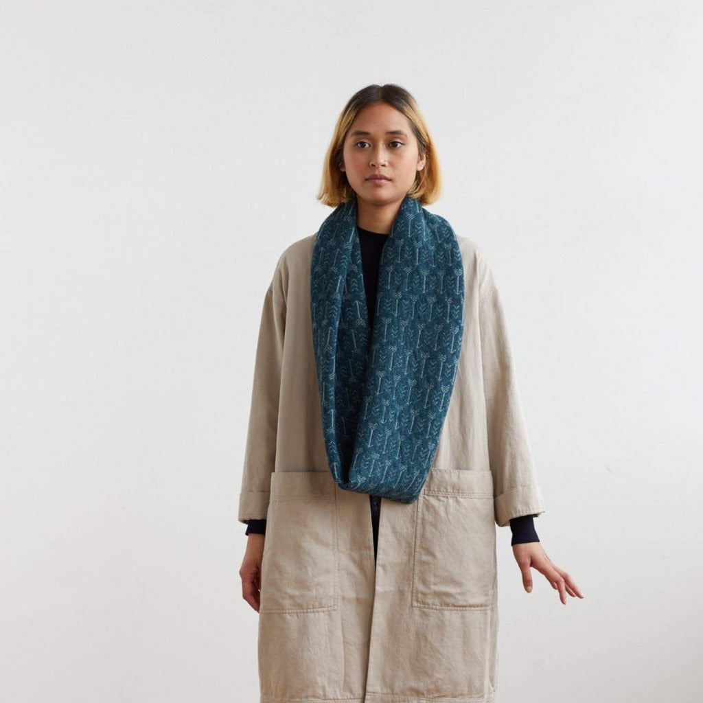 Teal infinity scarf with a subtle repeating pattern.