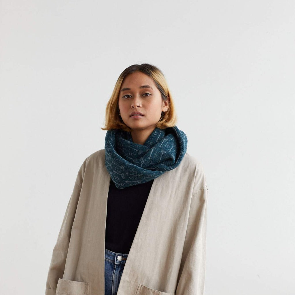 Teal infinity scarf with a subtle geometric pattern.