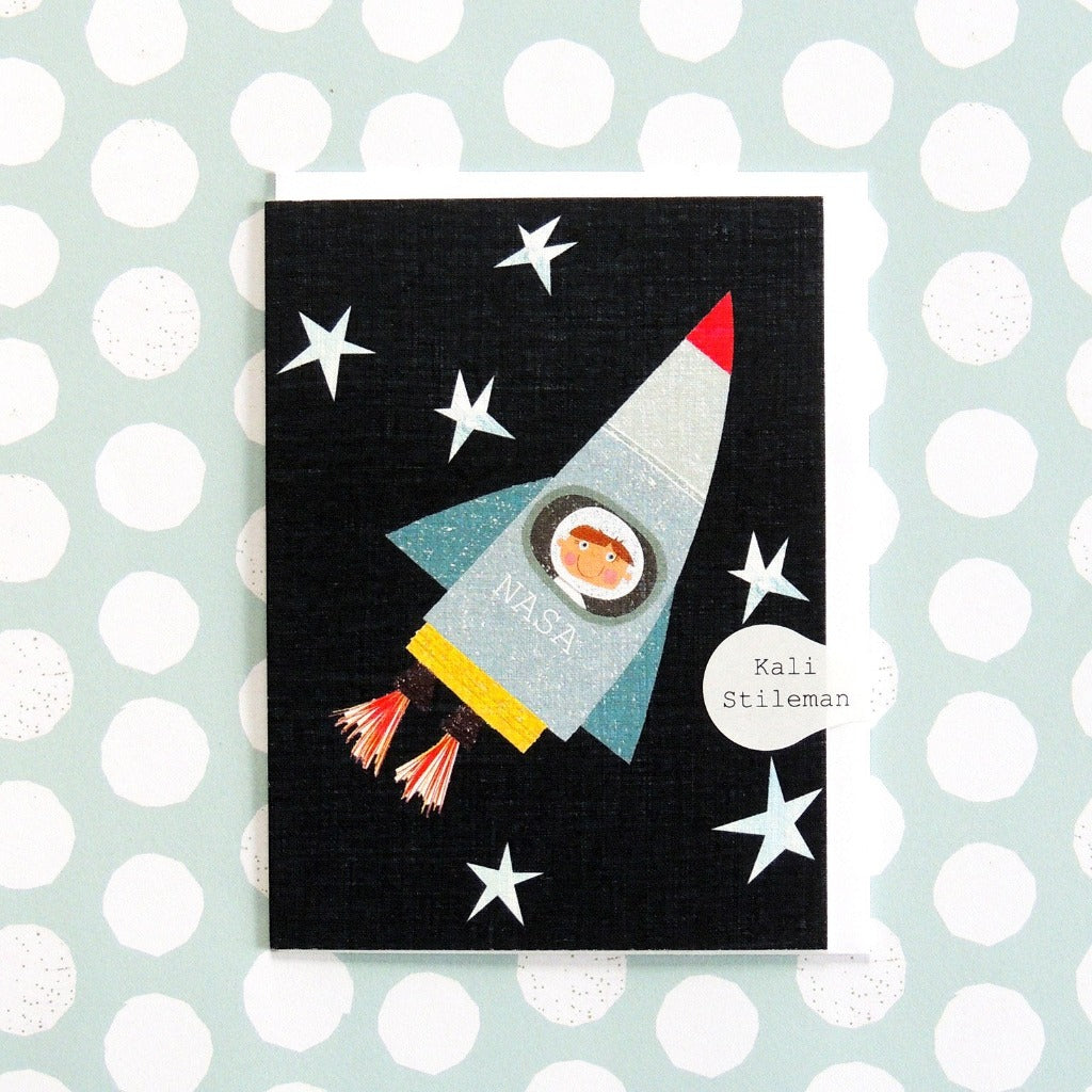 Greeting card depicting a child in a NASA rocket flying through space.