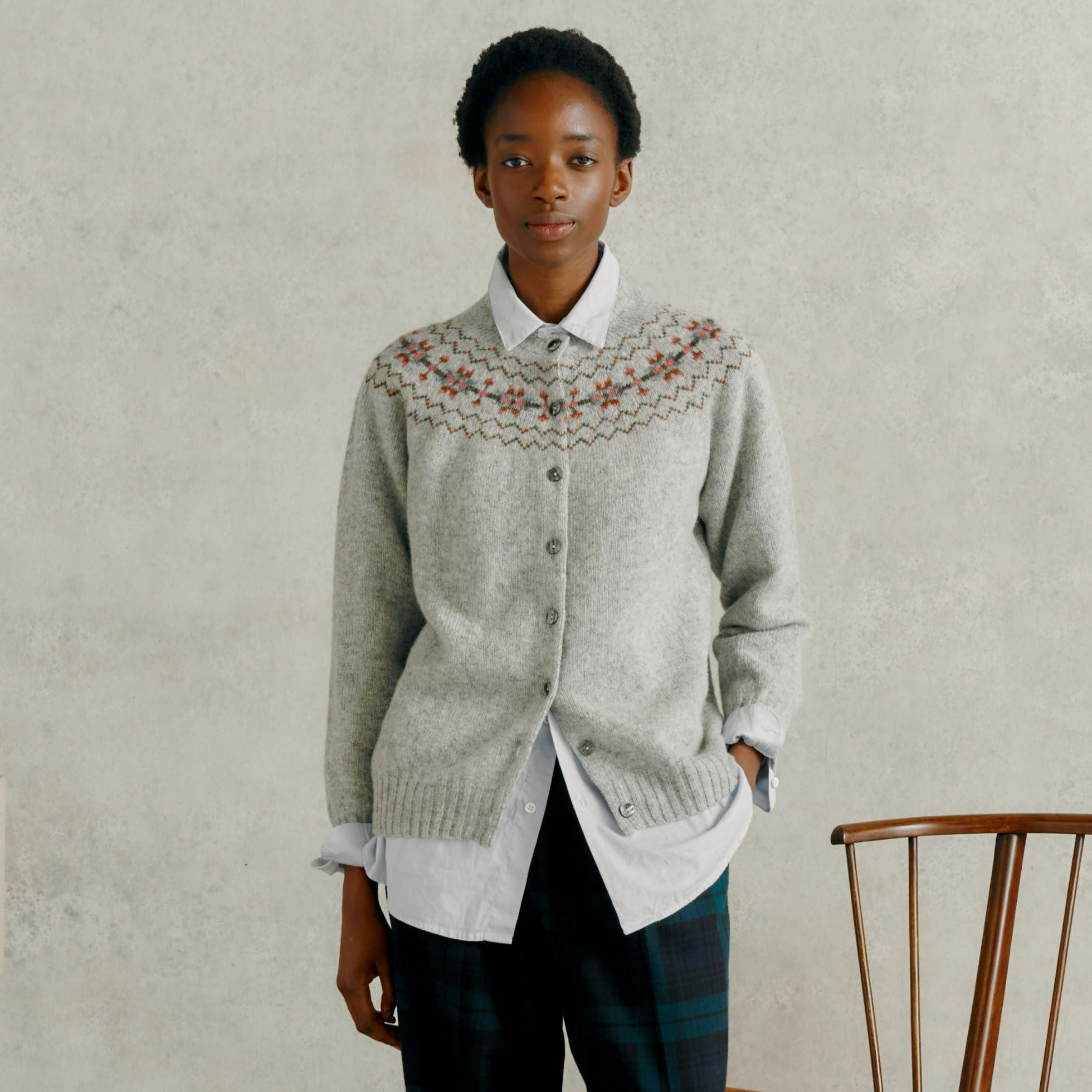 Light gray wool cardigan with a Fair Isle-inspired yoke featuring muted floral and geometric patterns. Button front closure.