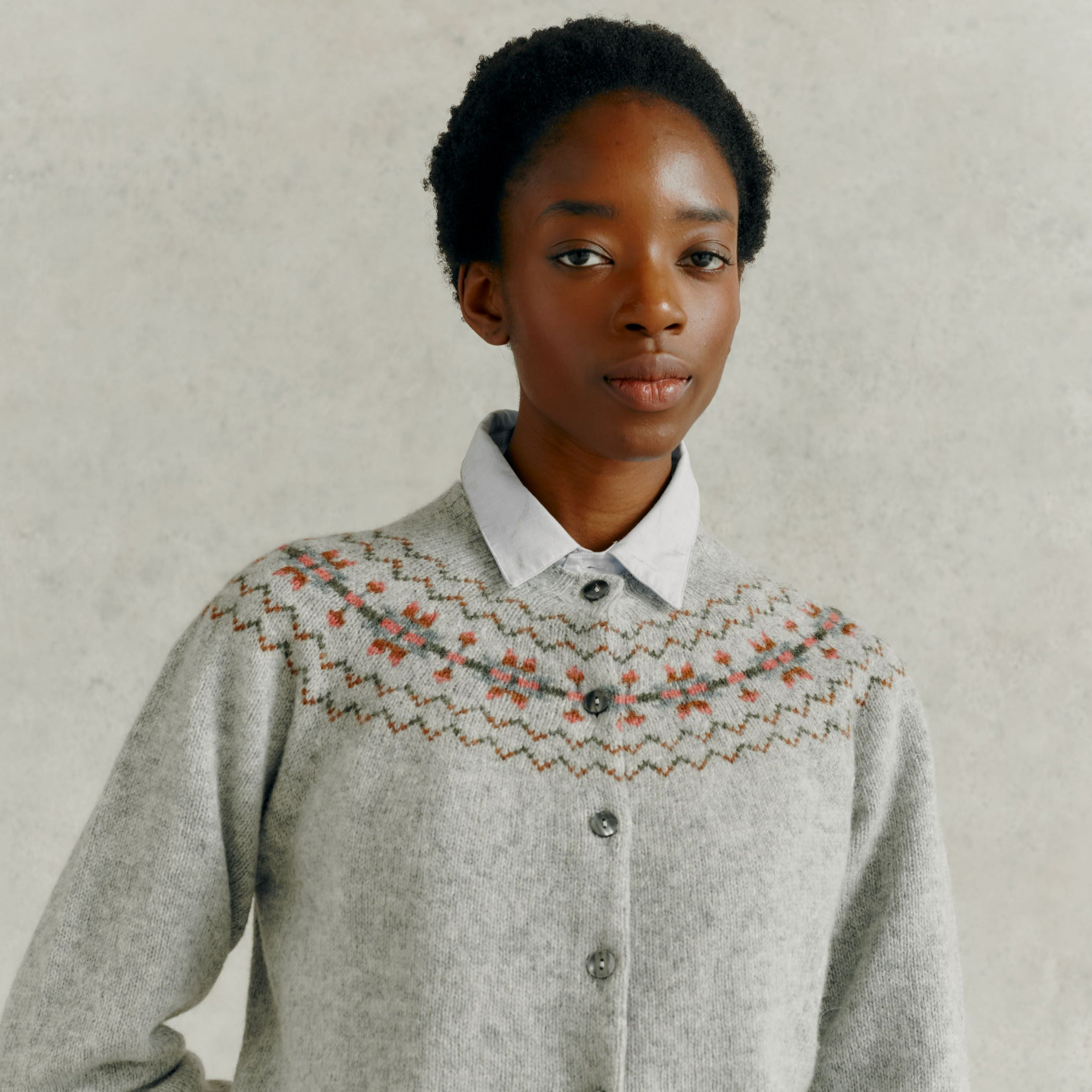Light gray wool cardigan with a patterned yoke featuring muted greens, browns, and pinks.