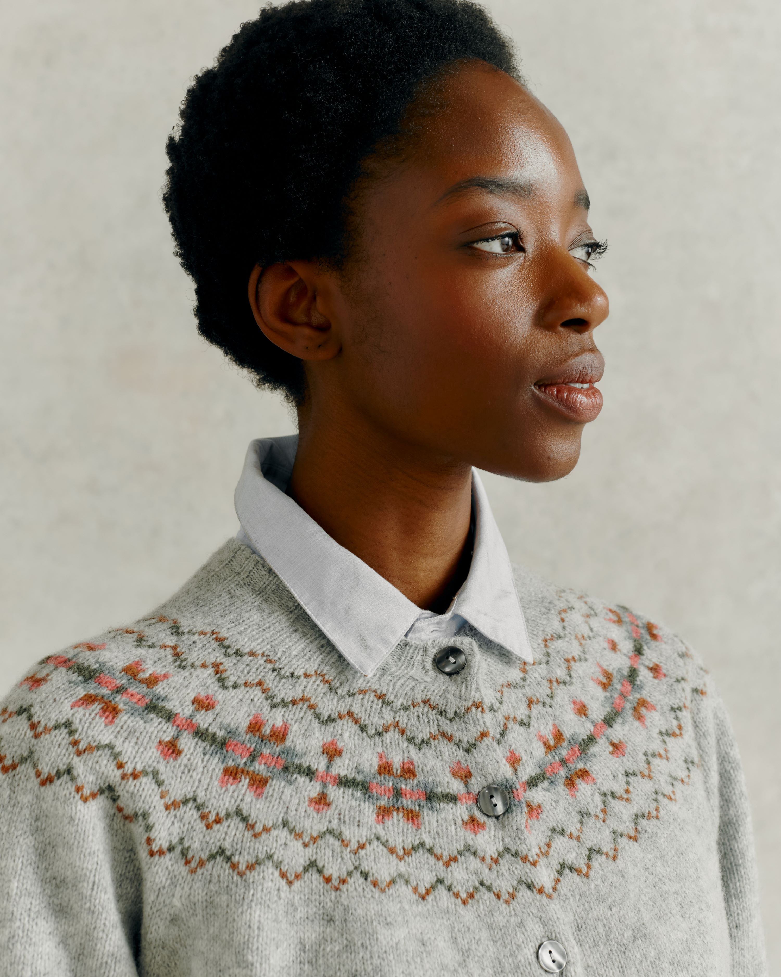 Grey wool cardigan with a patterned yoke featuring muted pink, green, and brown floral details.